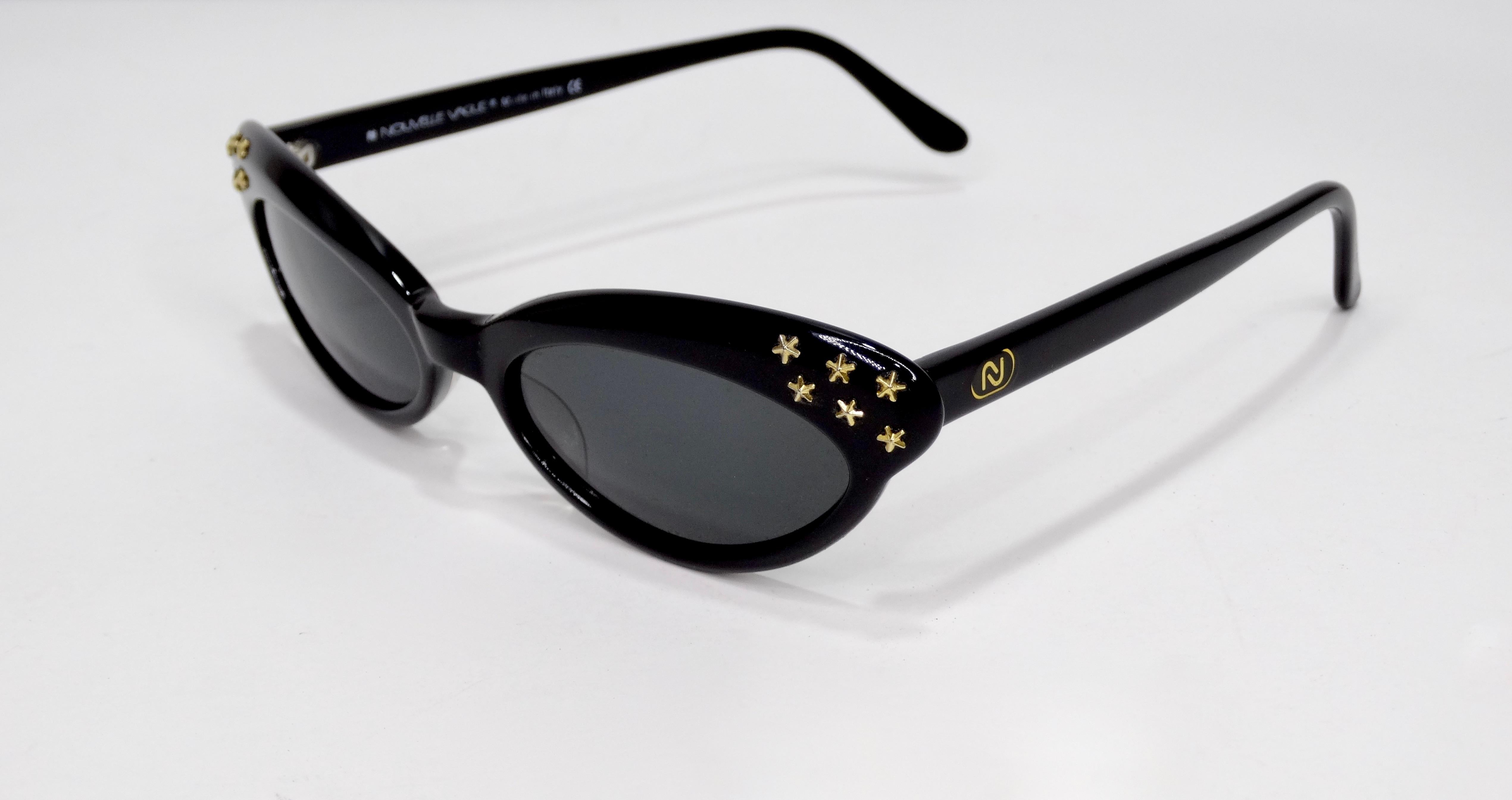 Elevate your look with these adorable late 1980s/early 1990s Nouvelle Vague sunglasses! Feature a cat eye frame with mini gold stars and black lenses. The perfect accessory to tie your together all your looks! Comes with original case. Stamped made