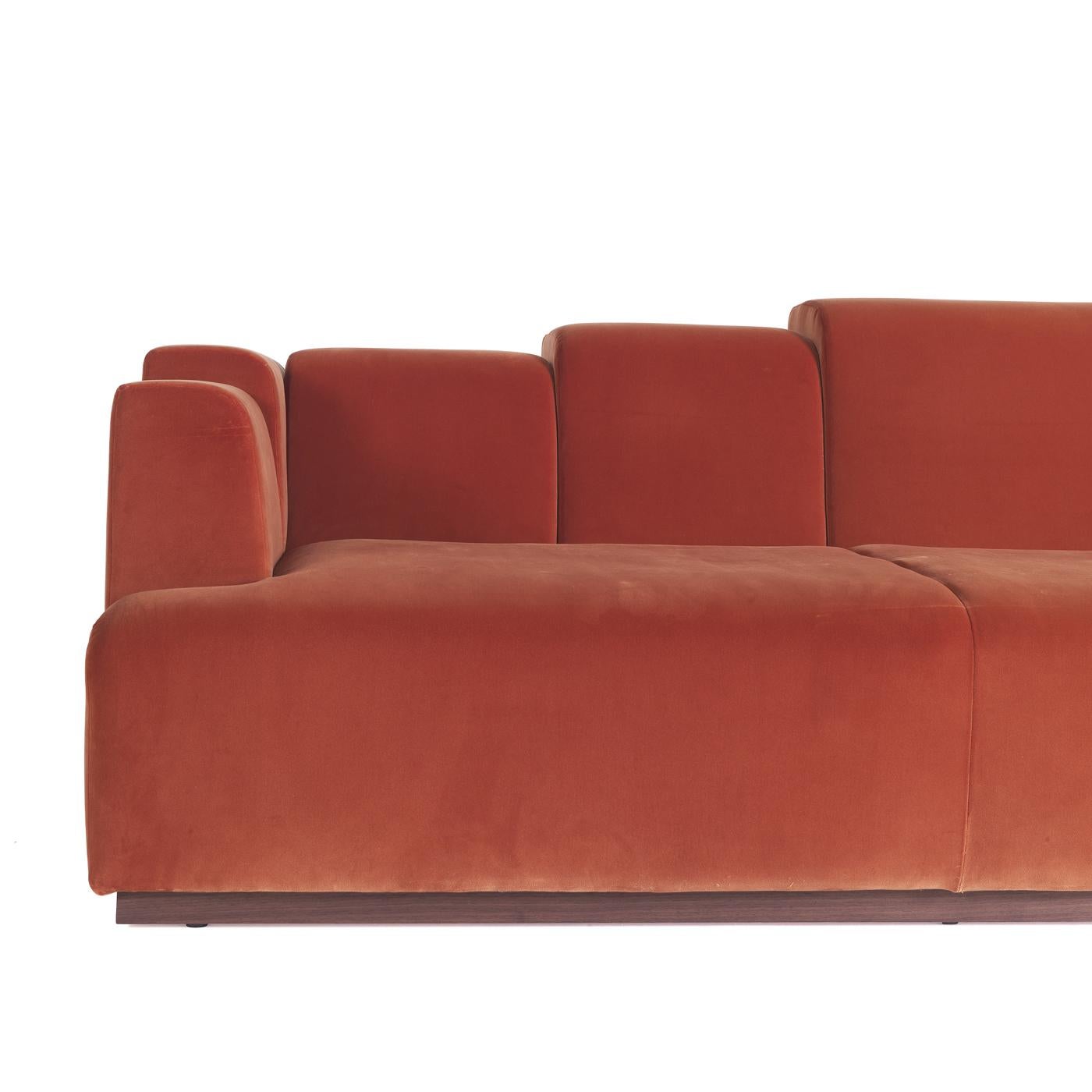 Inspired by the 1980s style, this striking sofa is a one-of-a-kind piece that will make a statement in any living room. Boasting a brick red color, it is marked by a unique back with sections of different measures that create a captivating and