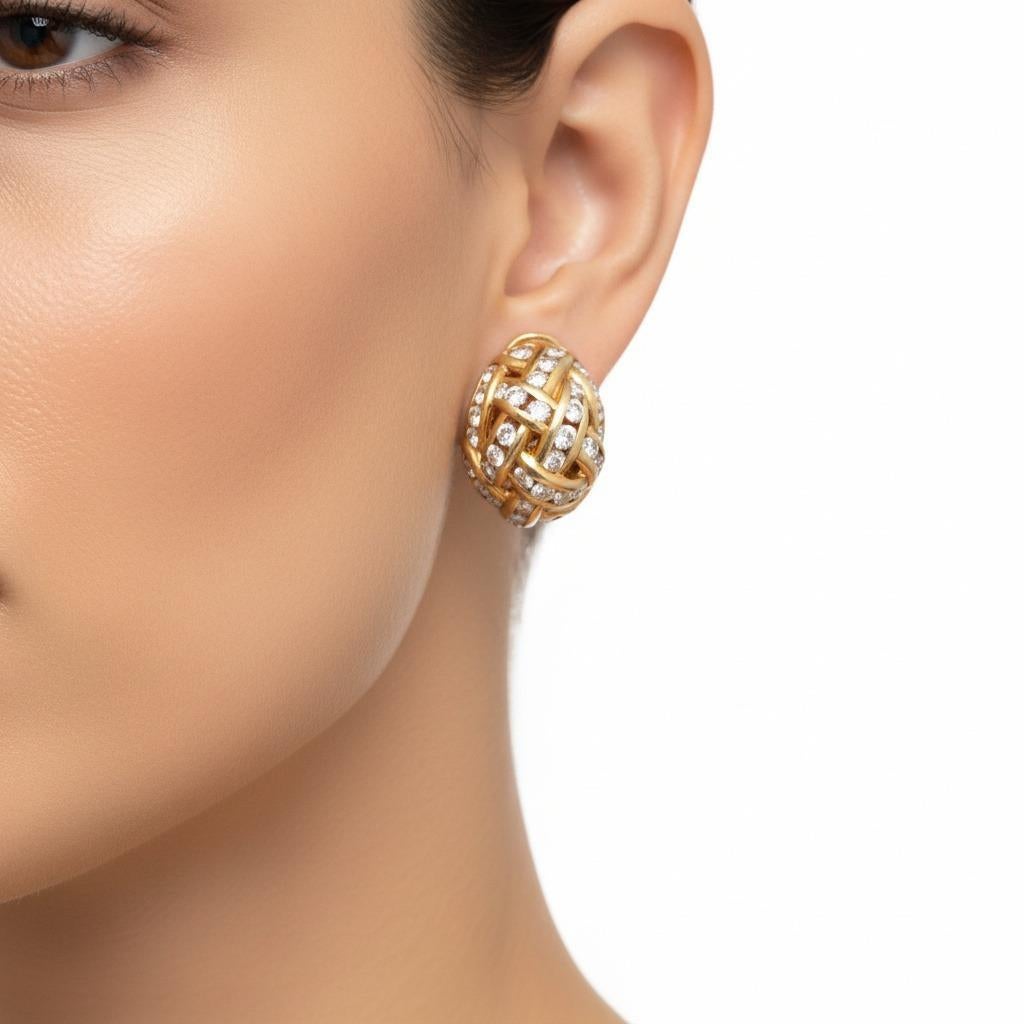 Questo splendido paio di orecchini a cerchio mostra un'eccezionale maestria contemporanea, sapientemente realizzata in lucente oro giallo 18 carati e caratterizzata da un elegante motivo intrecciato impreziosito da 92 diamanti a taglio rotondo per