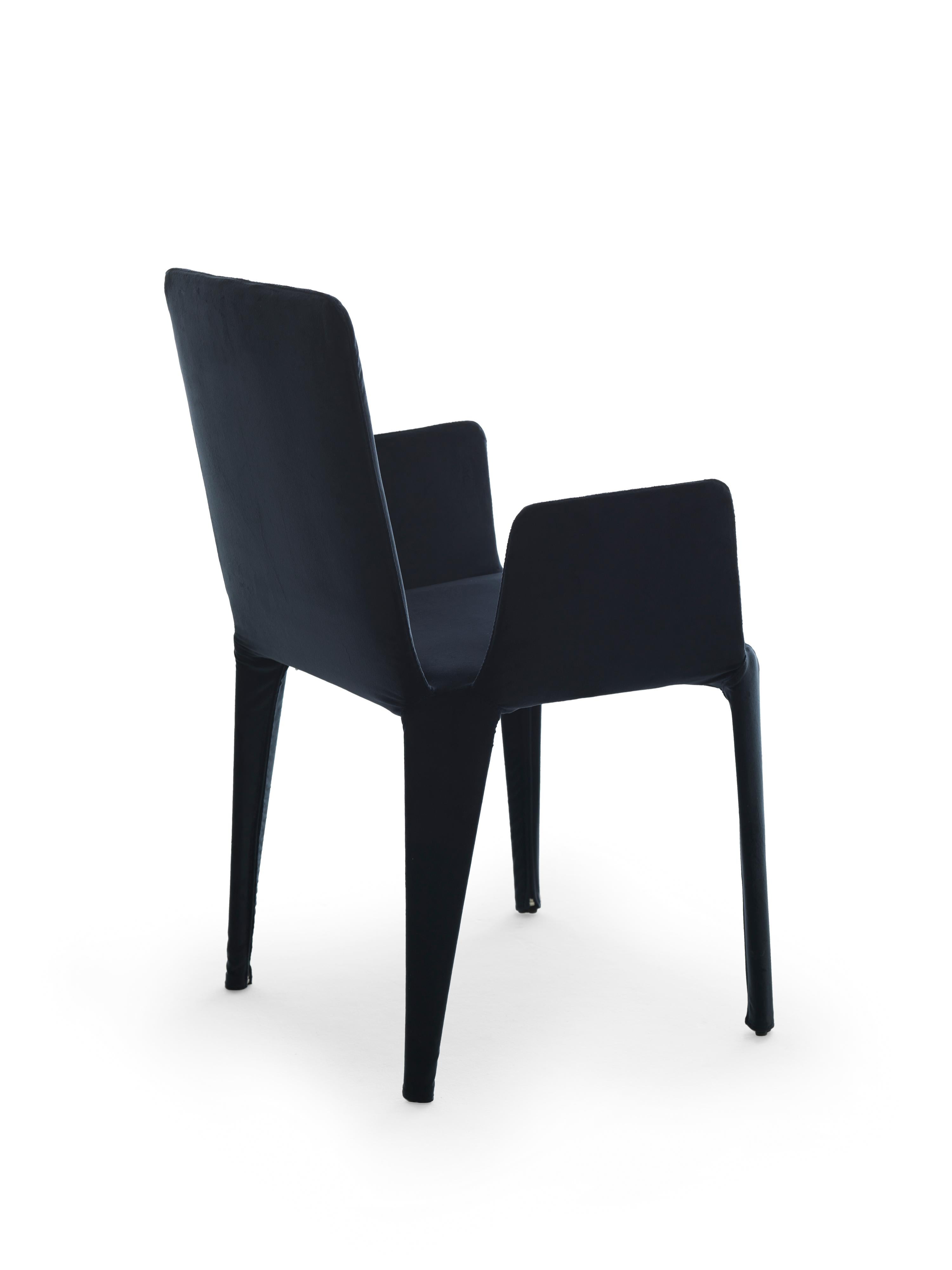 Nova est une chaise légère en textile au look précieux, entièrement déhoussable. La structure interne est un squelette minimal de tiges métalliques qui soutient les sangles élastiques et les coussins en polyuréthane et qui détermine la forme de la