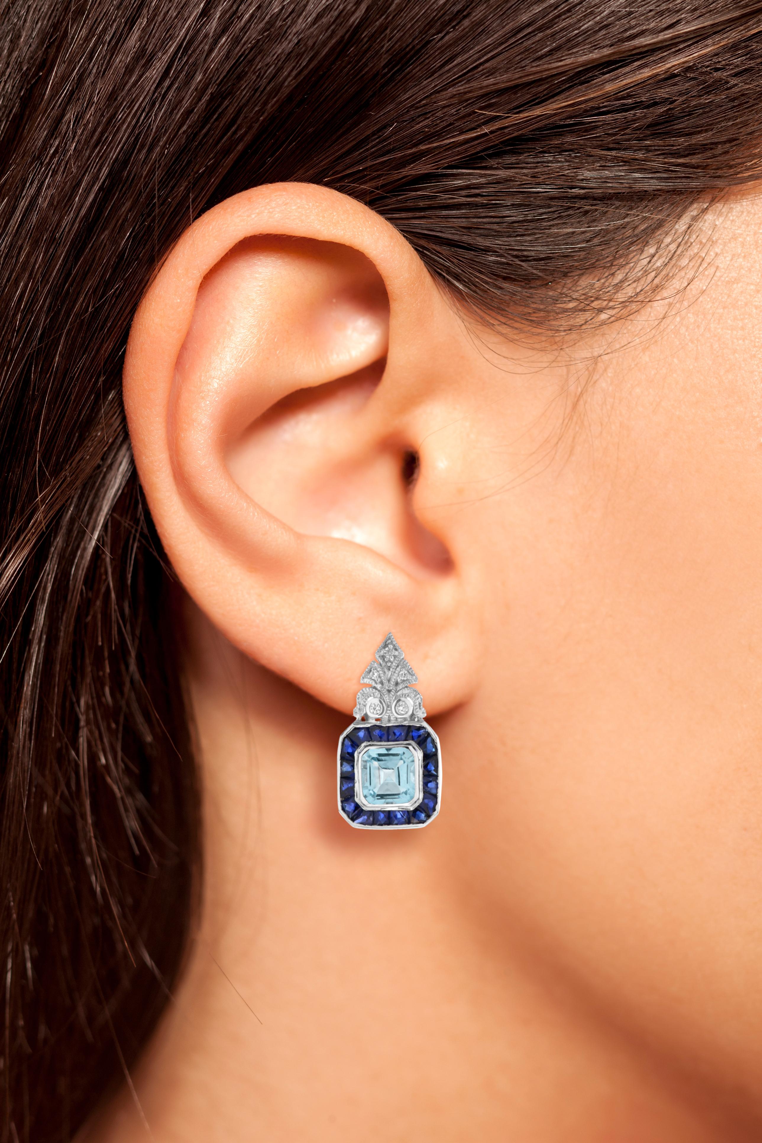 A pair of vintage aquamarine drop earrings, each earring consisted of an emerald cut aquamarine surround by a row of French cut sapphires, suspended from a round diamond-set top. These eye-catching earrings would pair perfectly with a sleek cocktail