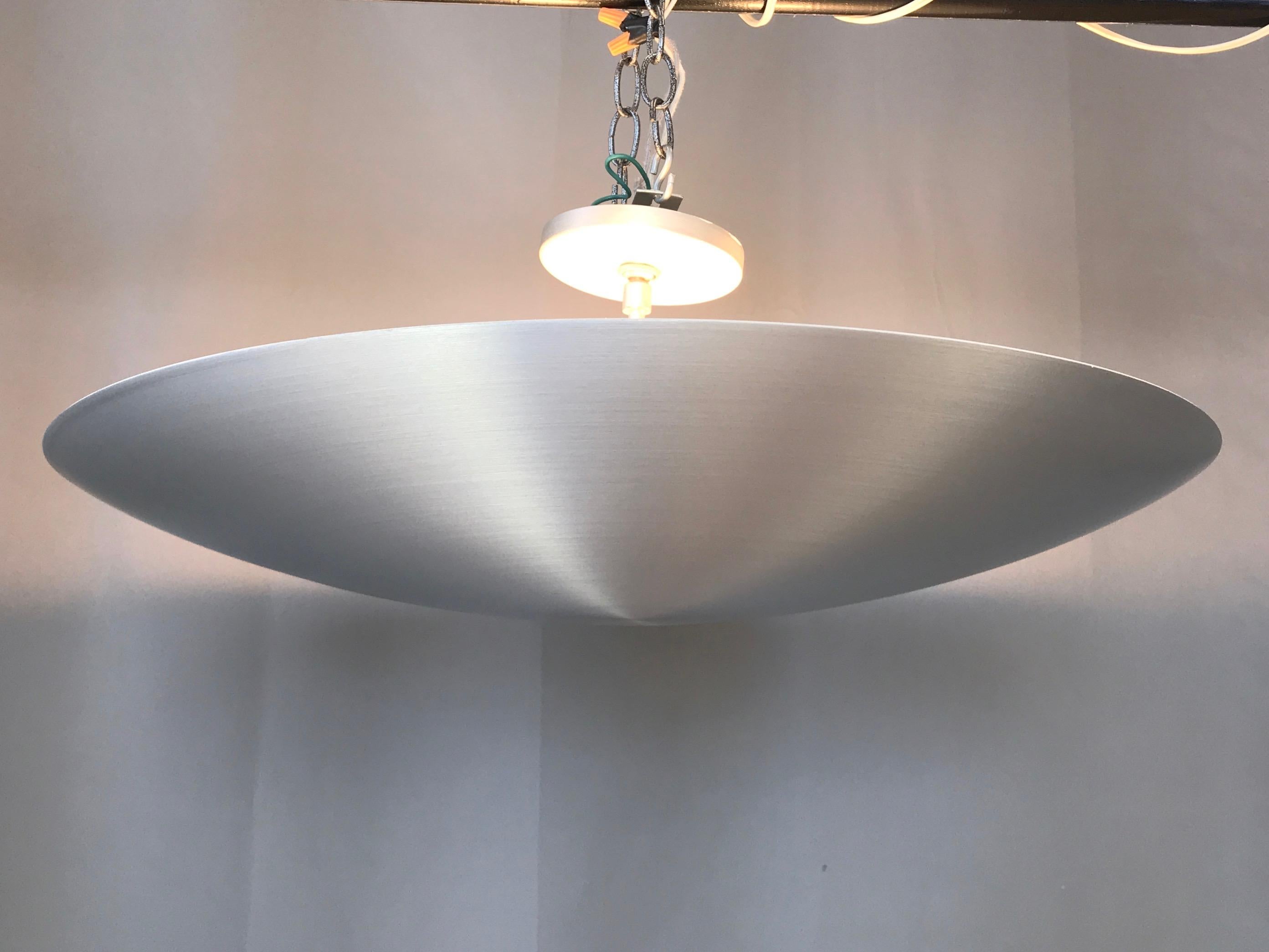 An exactingly fabricated and uncommon spun aluminum pendant ceiling light by Nova Industries of San Leandro, California.

Large, low profile, super sleek saucer design with brushed finish appears to hover UFO-like over head. Three ceramic sockets,