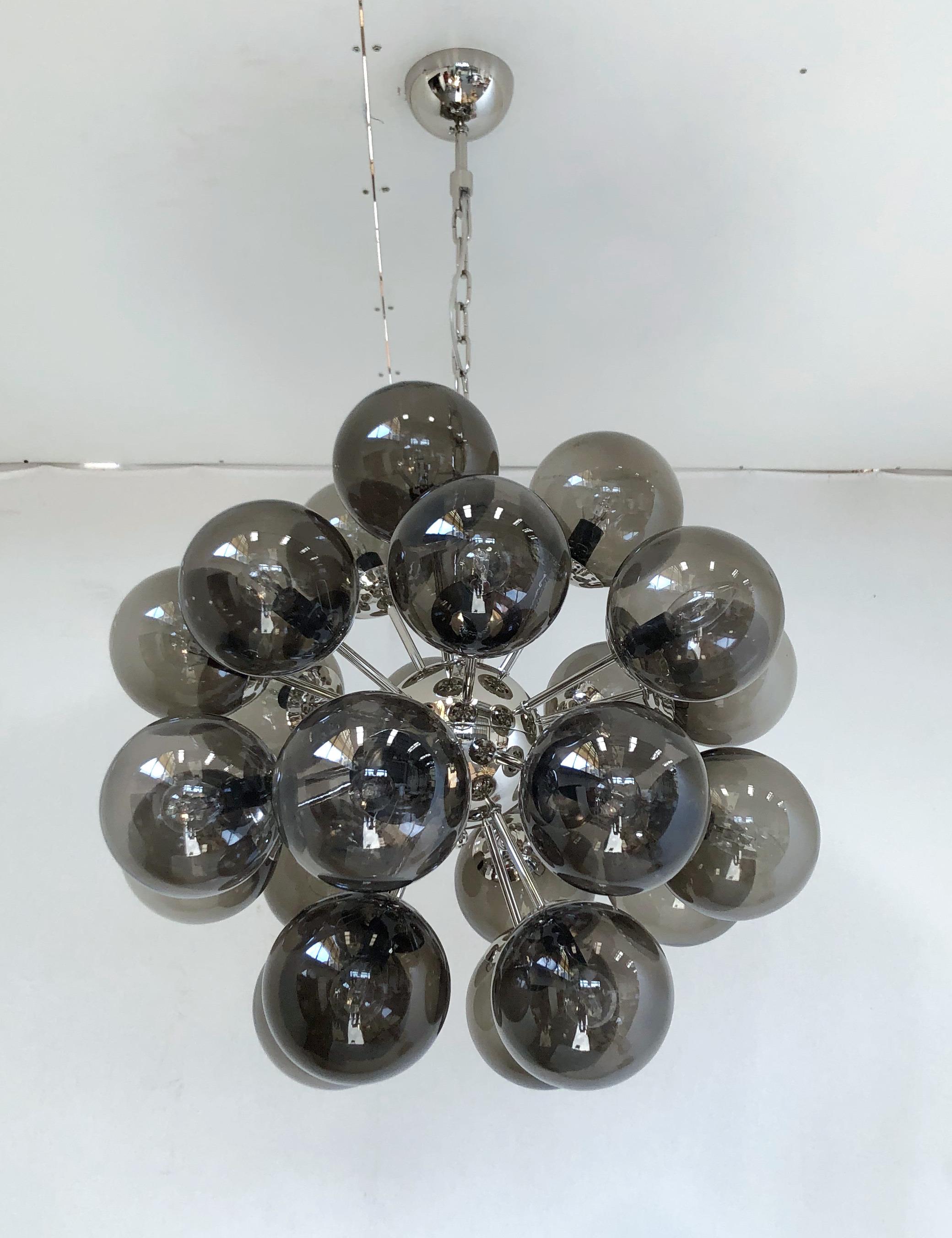 Lustre italien en forme de sputnik avec 24 globes en verre de Murano montés sur une structure métallique en finition nickel poli / conçu par Fabio Bergomi pour Fabio Ltd / Fabriqué en Italie.
24 lampes / type E12 ou E14 / max 40W chacune
Mesures :