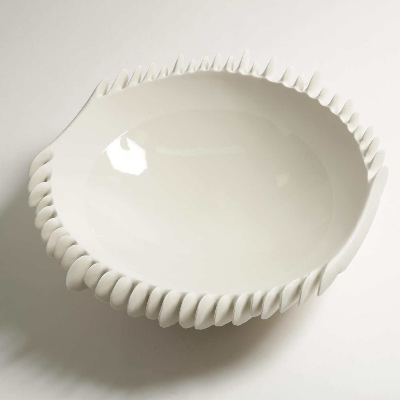 The smooth surface of a snow-white porcelain shell is riddled on the outside with fine crevices. A meticulously crafted mold and the use of unglazed porcelain, or 
