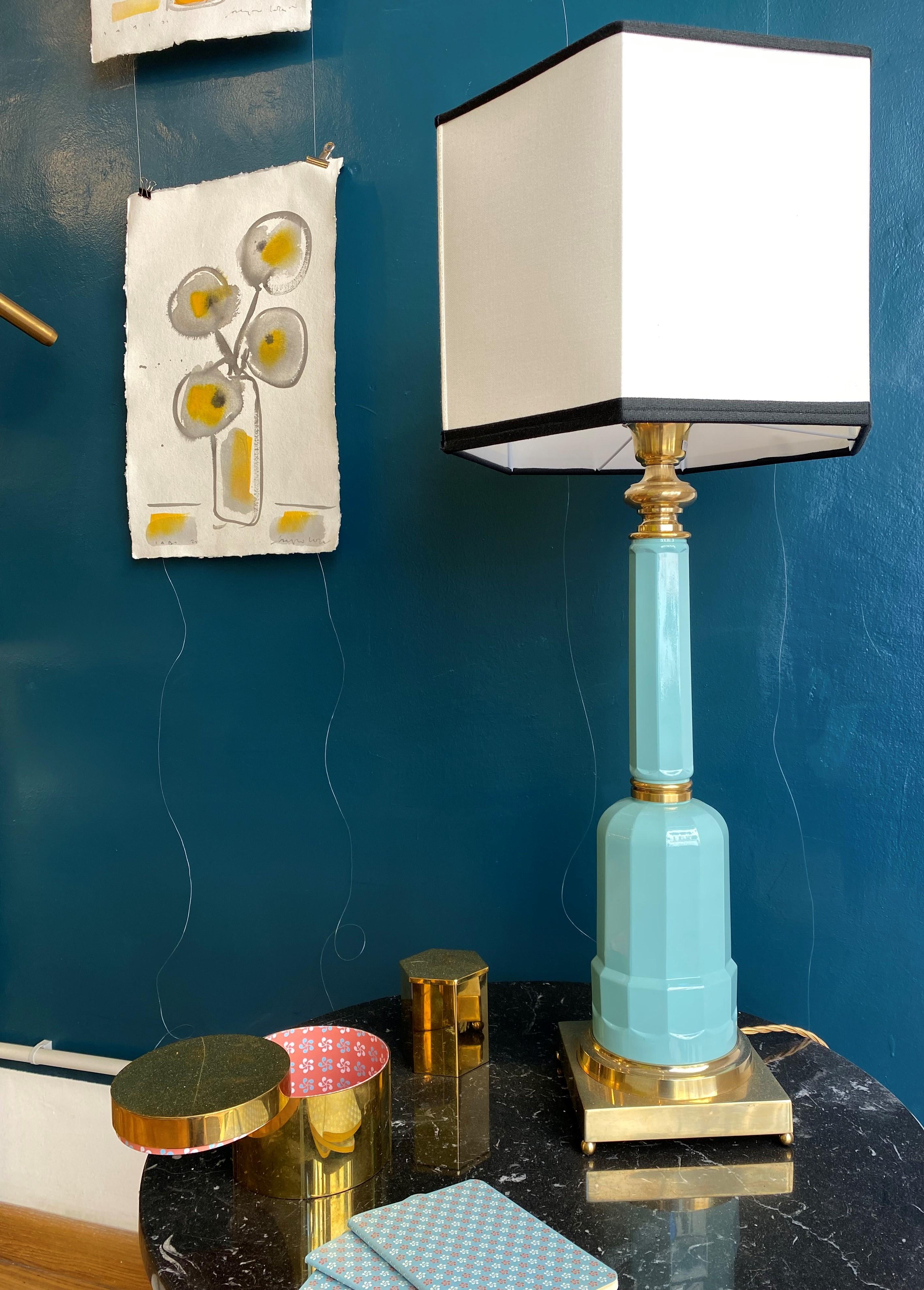 La lampe de table Jacaranda est fabriquée en verre soufflé avec la base et les détails en laiton, finition naturelle, et abat-jour en tissu. La structure en verre est obtenue par la technique artisanale du soufflage de verre à l'intérieur d'un