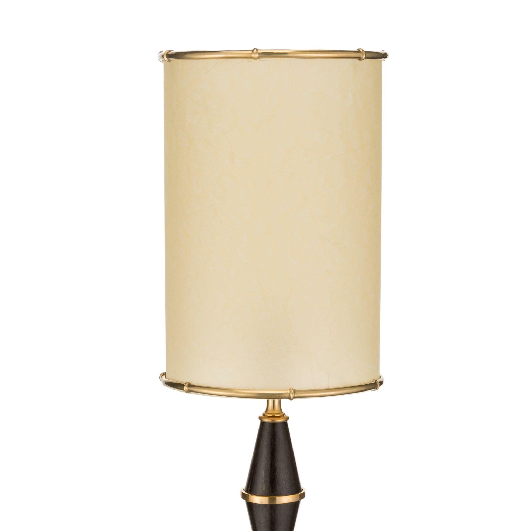 This particular table lamp belongs to the Urban line of the Brass Brothers & Co. collection, its structure is made of small black waxed brass cones assembled one in a way and one in the opposite so as to form a rhombus shape. The base and the joints