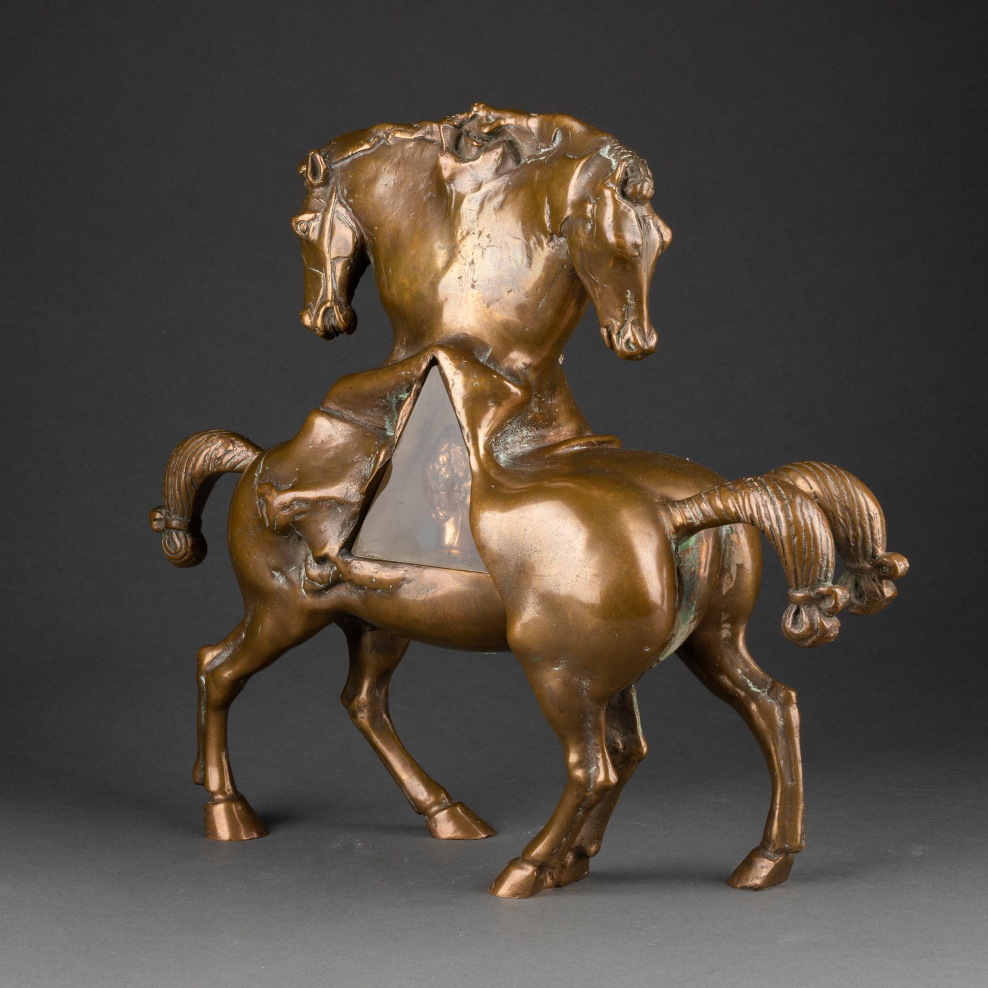 Novello FINOTTI (1939-, Italie)

'Guatemala'

Epreuve en bronze doré, représentant deux chevaux surréalistes, avec inclusion pyramidale en plexiglas d'une tête de personnage / Golded colour bronze sculpture representing a couple of surrealists