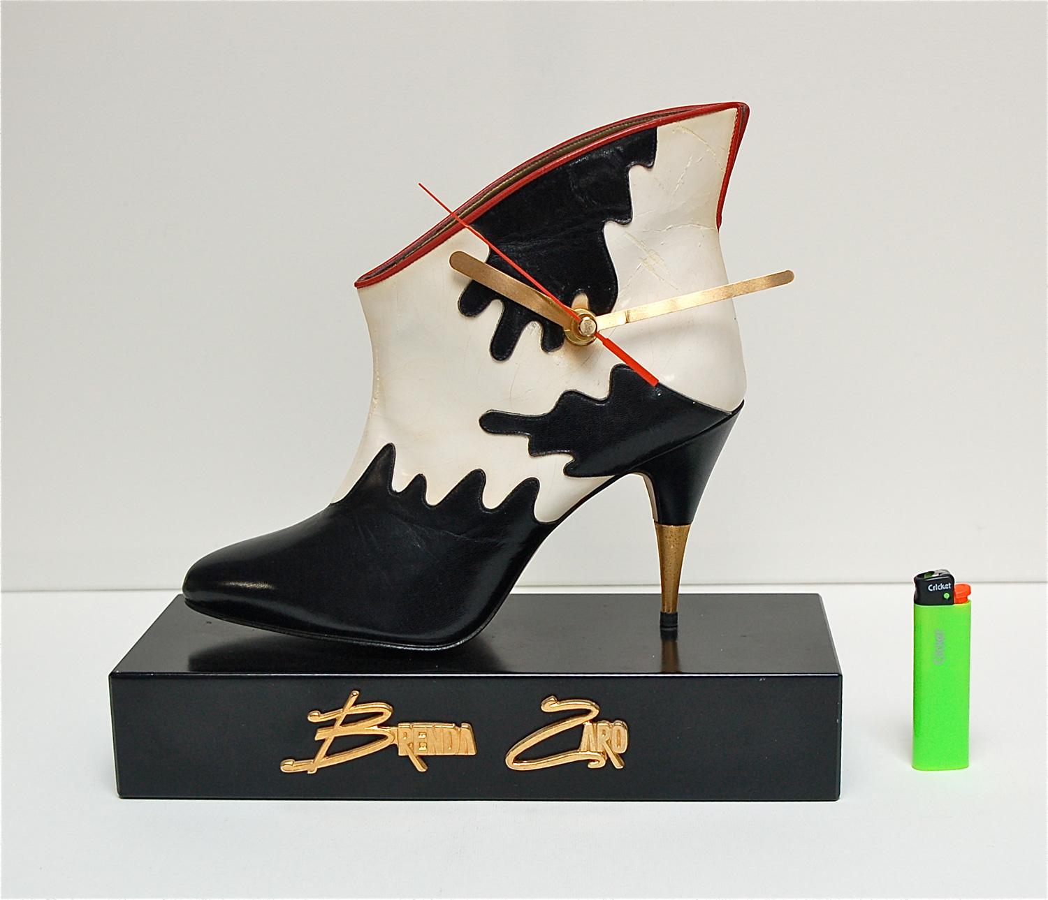 This former advertising item or merchandising item is a rare find as they often were discarded at the end of the fashion season. It's a novelty table or desk clock made from a black and white cow print ankle boot by shoe designer Brenda Zaro. The