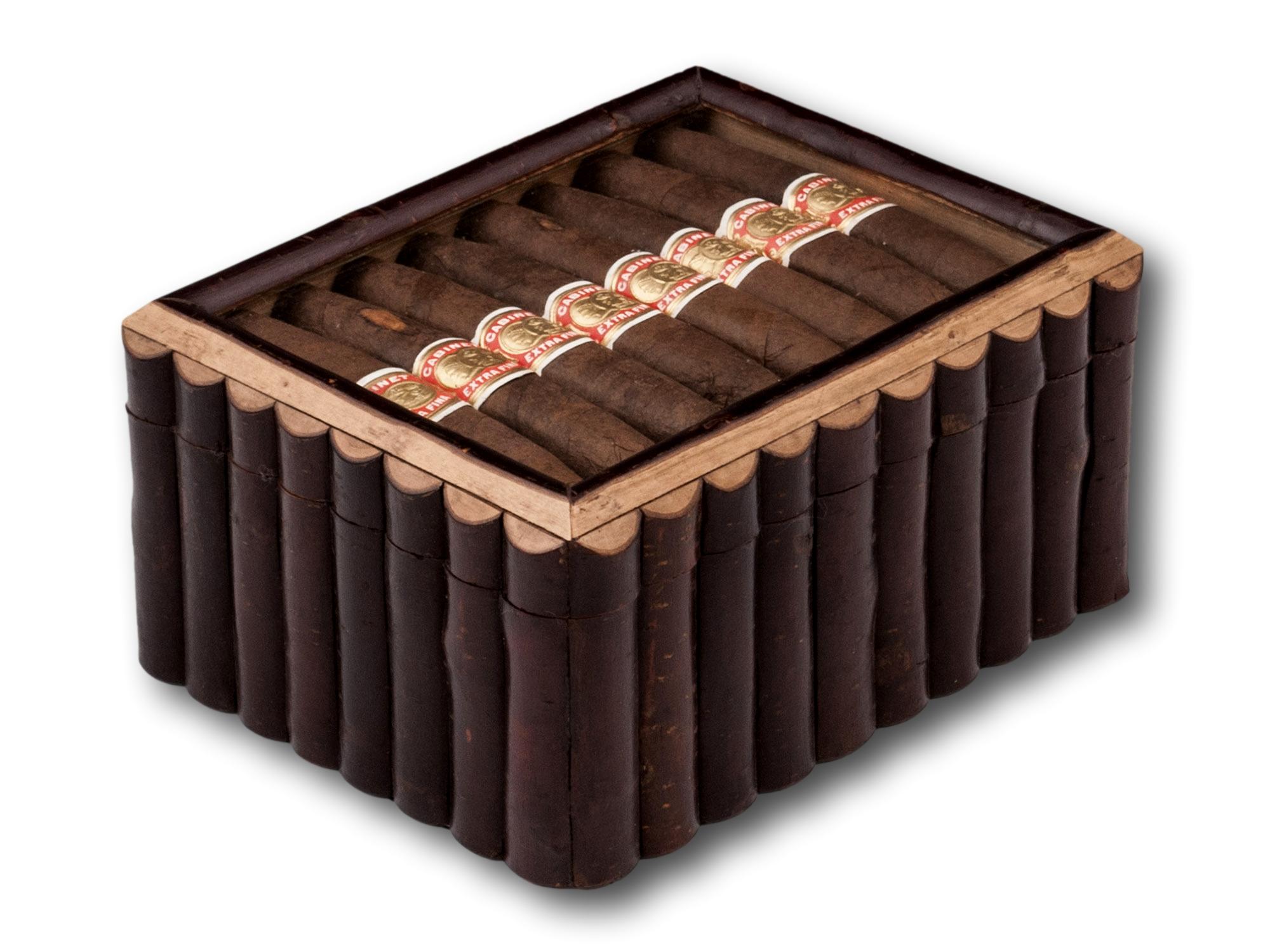 Novelty Cigar Topped Humidor

The box of oblong shape with a ribbed exterior crafted from Birchwood Bark with a fantastic Novelty lid housing eight Cabinet extra fine cigars. When opened the humidor reveals a maple lining perfect for storing your