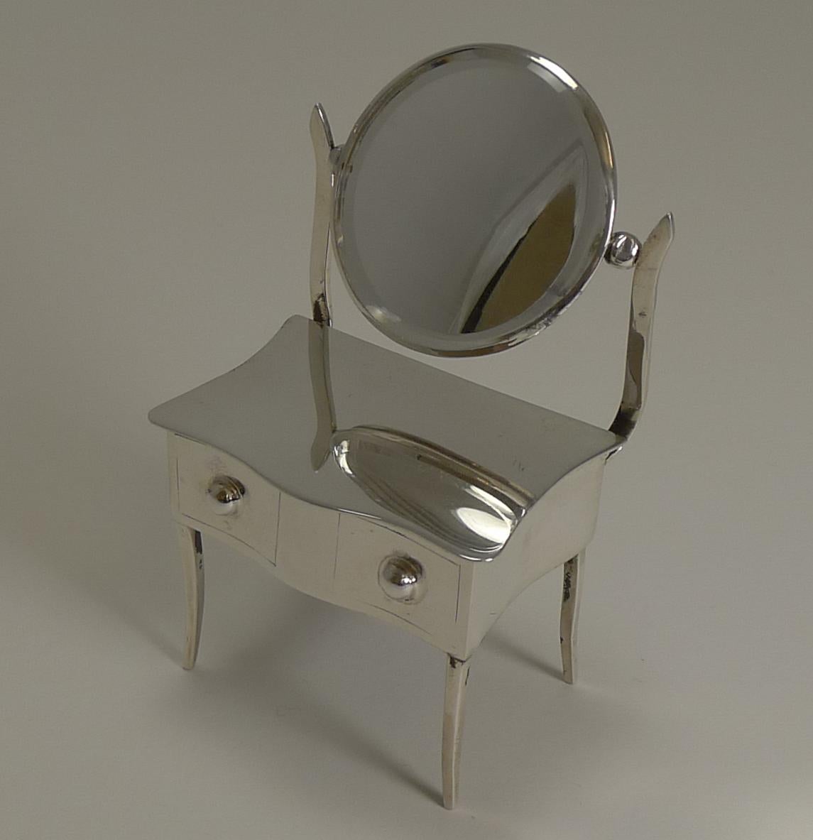 A really charming novelty sterling silver jewelry or ring box modelled in the form of a dressing table including a swing mirror to the back with it's original beveled mirror (minor surface scratches to mirror commensurate with age).

The