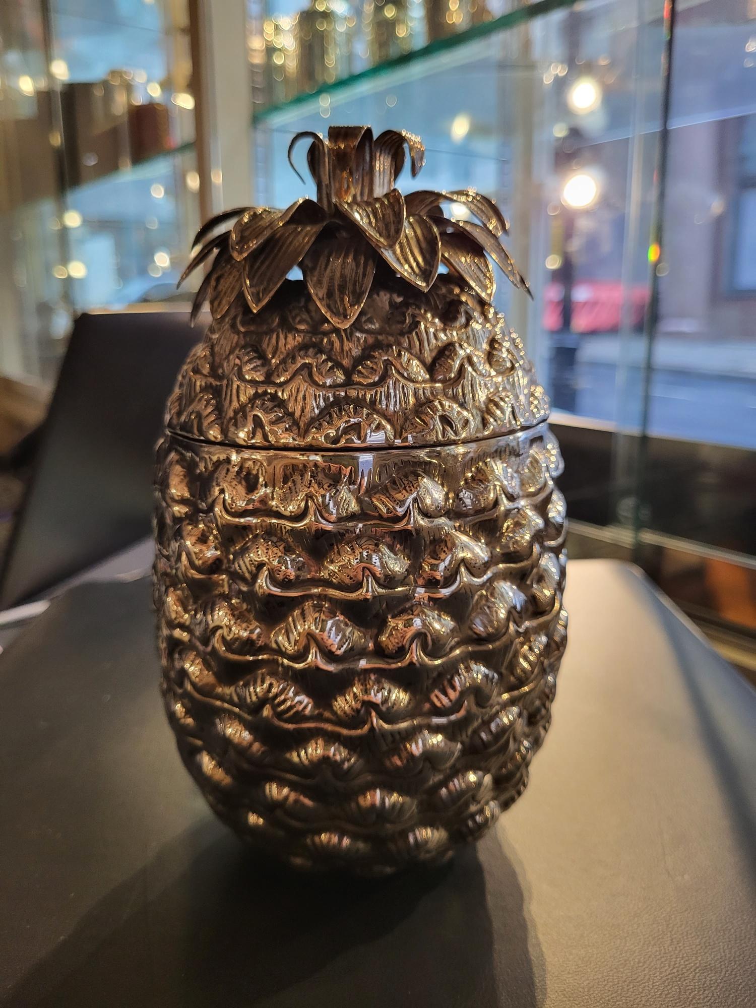 Alessandria, Italy

An extremely unusual and decorative silver pineapple-form lidded box, or perhaps can be used as a personal bucket for ice cubes, with a realistic-modelled body with a crown of leaves, the lid lifting to reveal a fully gilded