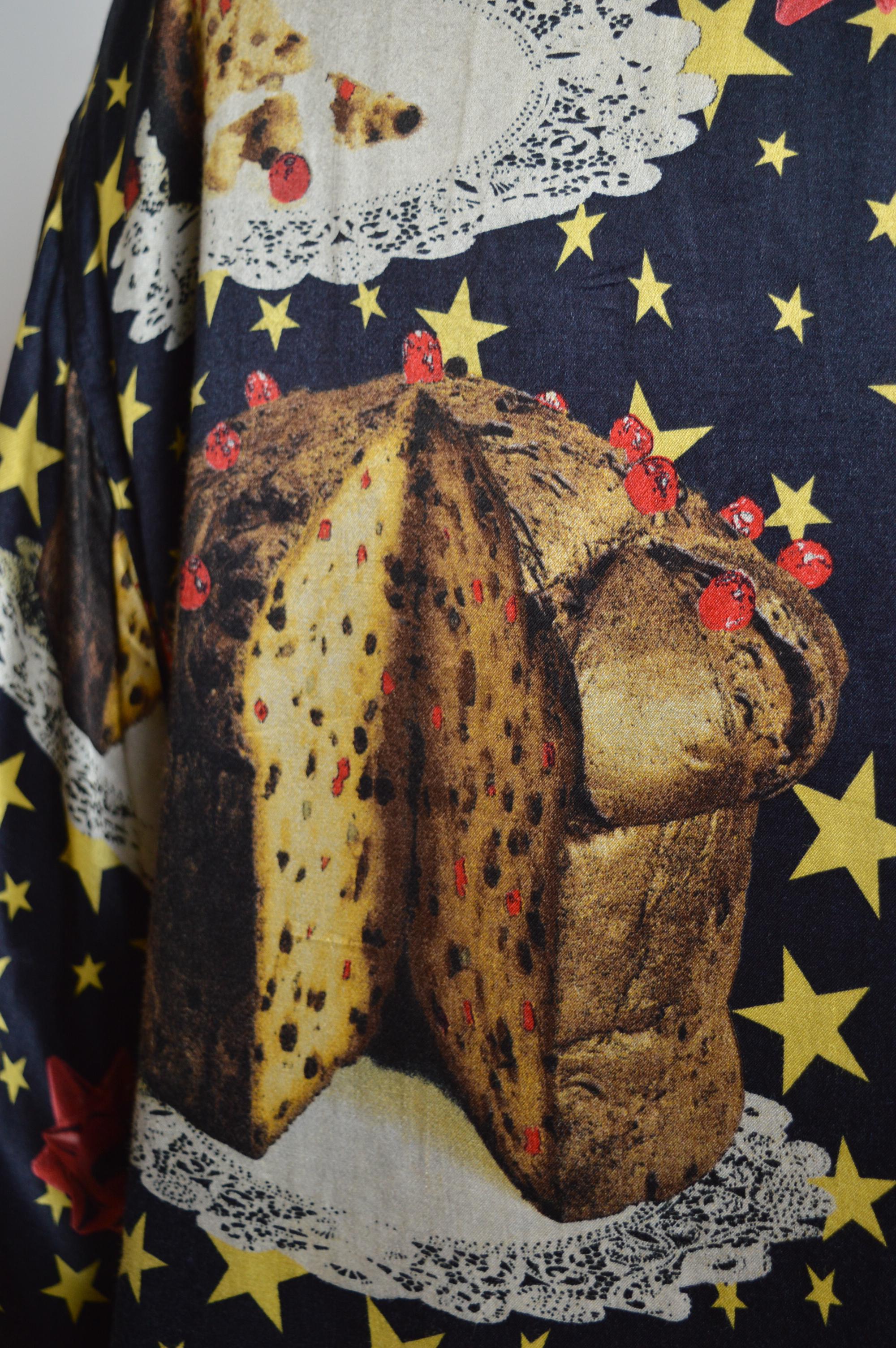 Novelty Moschino 1990s Festive Italian Panettone Loud Colourful print shirt 
Made in Italy.
Satin feel material / Long sleeves / Gold Buttons down the front / Loose fitting
Pit to Pit; 23”
Pit to Cuff; 20”
Nape to Hem; 32”
Size; Medium
Condition;