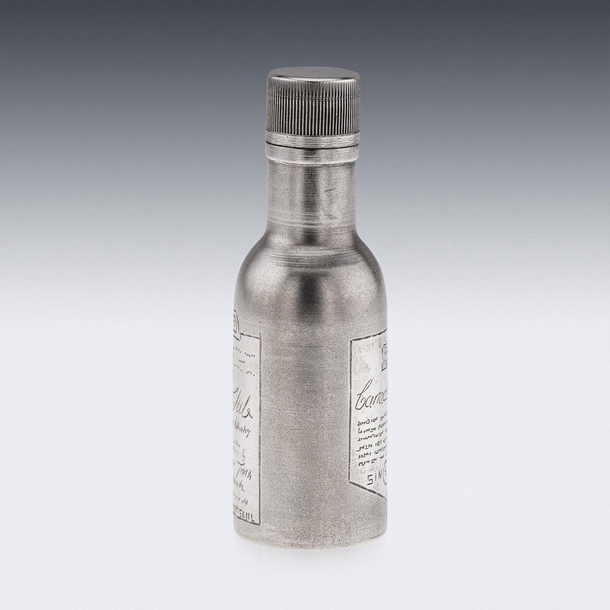 A novelty solid silver Canadian Club whisky bottle. Of a miniature size however heavy gauge throughout. A cylindrical form with a matted finish throughout. Engraved with the label to represent a Canadian Club bottle. The lid unscrews allowing the