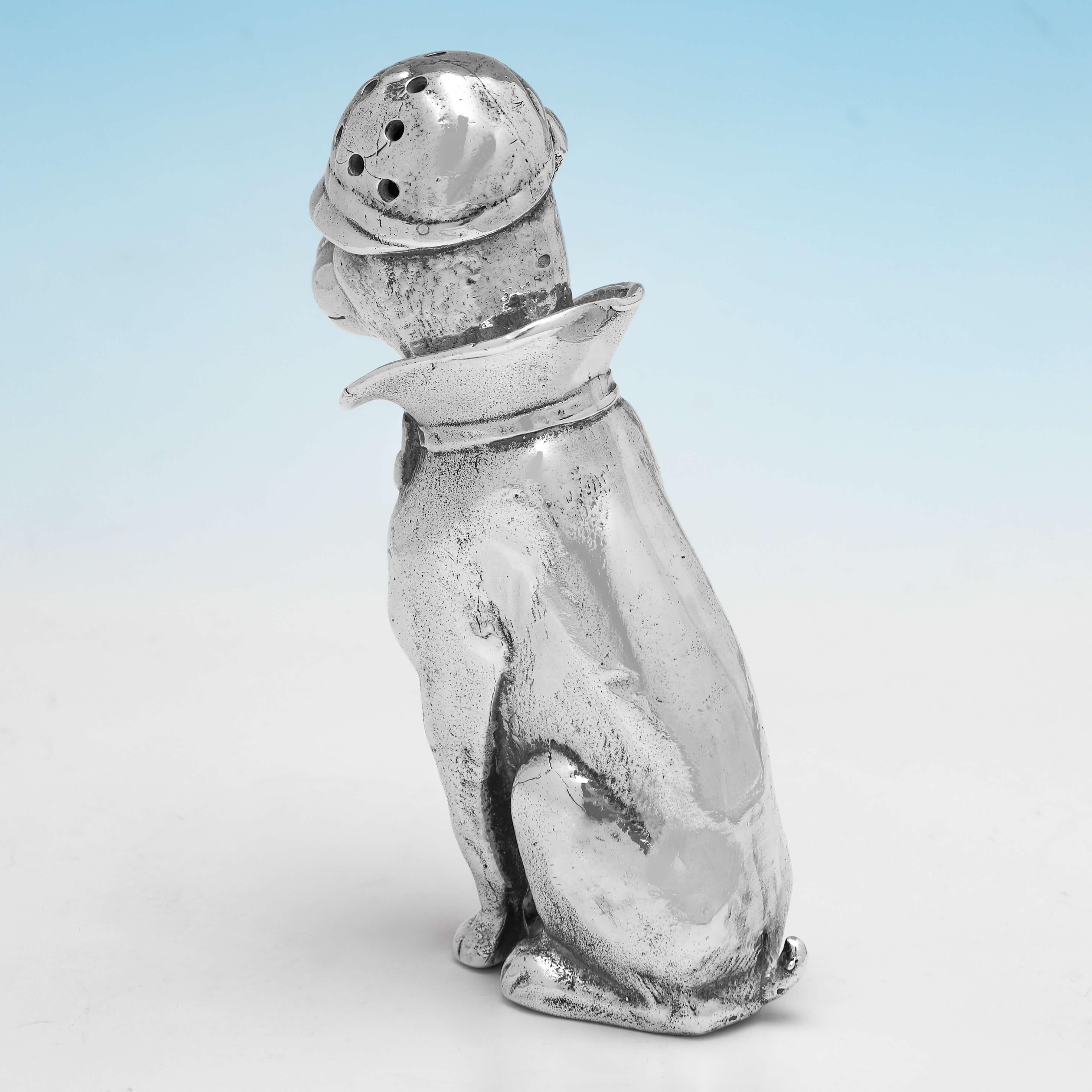 Hallmarked in London in 2000, this charming, sterling silver pepper pot, is fashioned as a dog wearing a hat and collar. The pepper pot measures 3.5