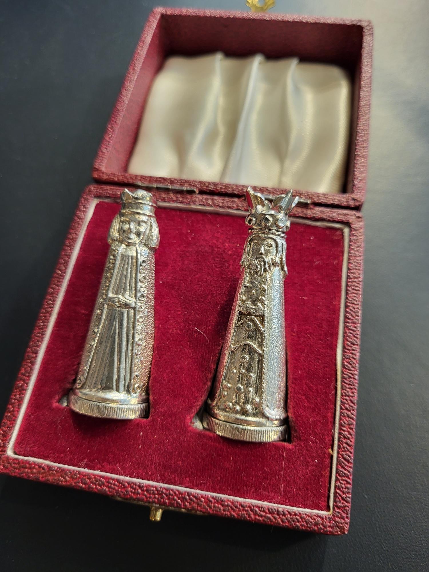 A characterful pair of extremely heavy-cast Sterling silver salt and pepper pots in the form of a King (salt) and his Queen (pepper), each character is wearing a long cloak, embellished with cast ‘jewels’ and fancy trim, the King with detailed