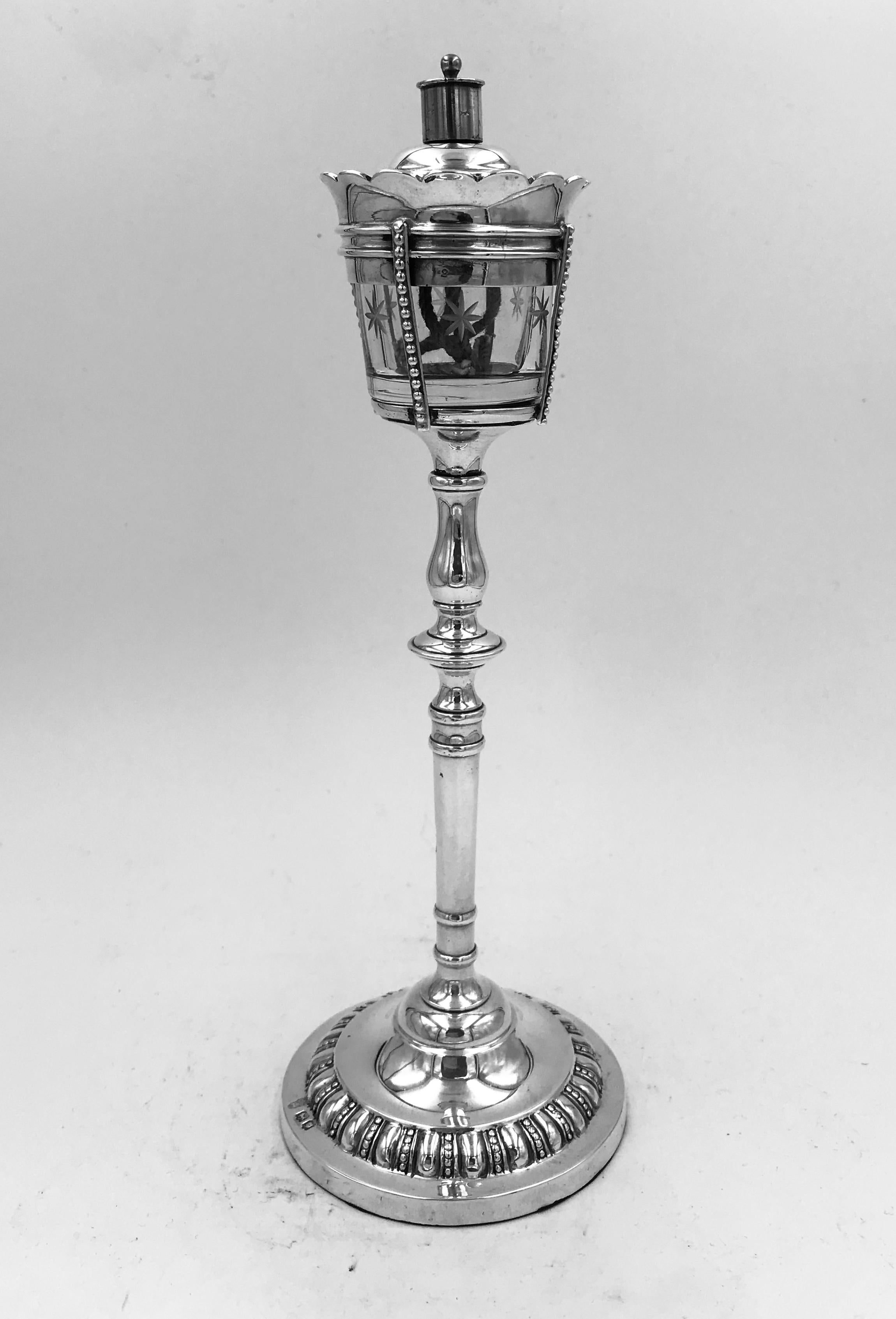 A George V sterling silver novelty table cigar lighter, London 1916 by Charles Stuart Harris In the form of streetlamp, the filled circular base with gadrooned band, the top section with removable silver mounted clear glass oil reservoir, with wheel