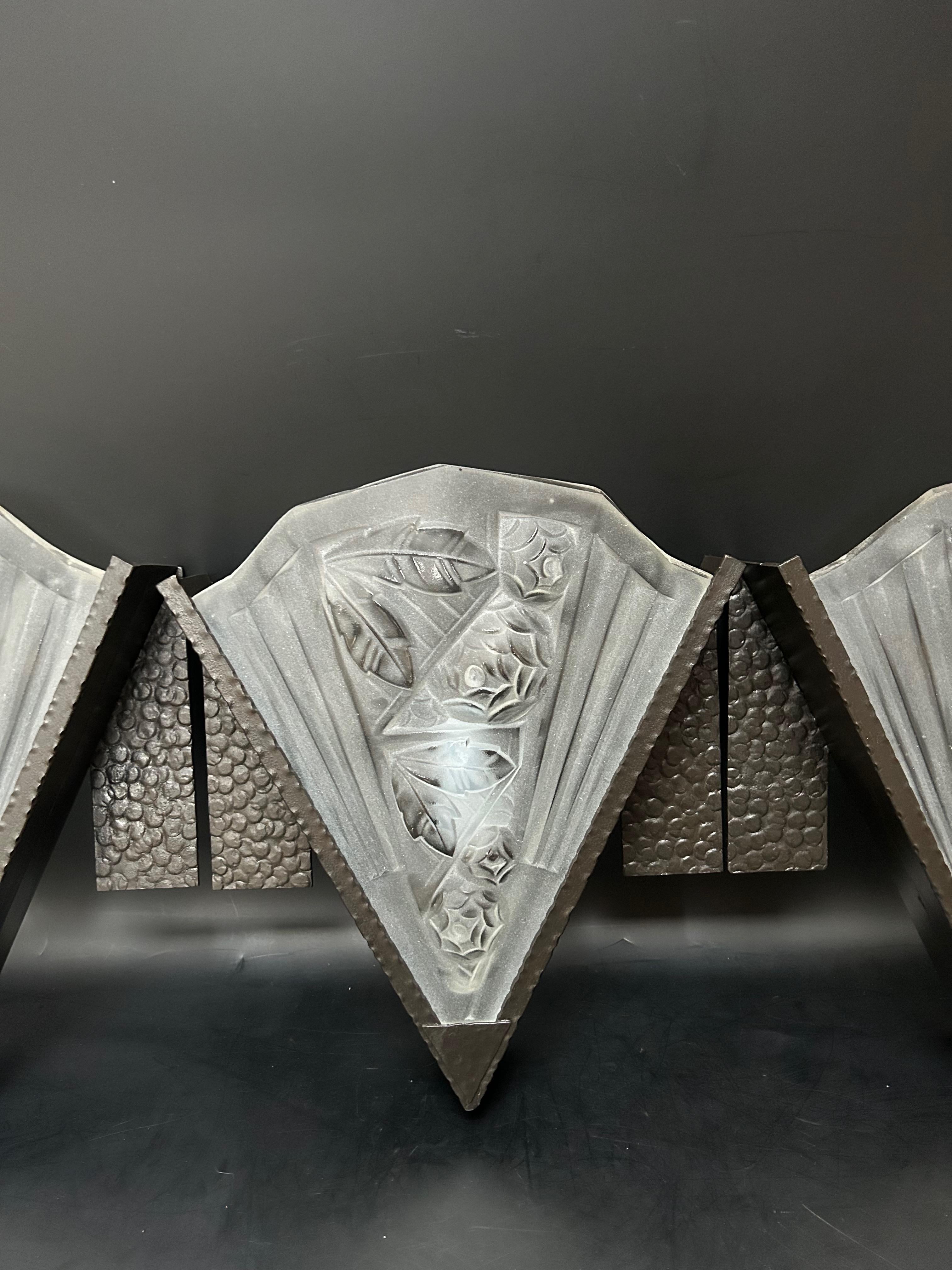 Suite of 3 art deco wall lights circa 1930.
Black patinated wrought iron frame, Noverdy molded glass plates, floral decoration.
 In perfect condition, electrify E 14 screw socket 
unsigned 

Width: 25,5 cm
Height: 30 cm
Depth: 8,7 cm
Weight: 6