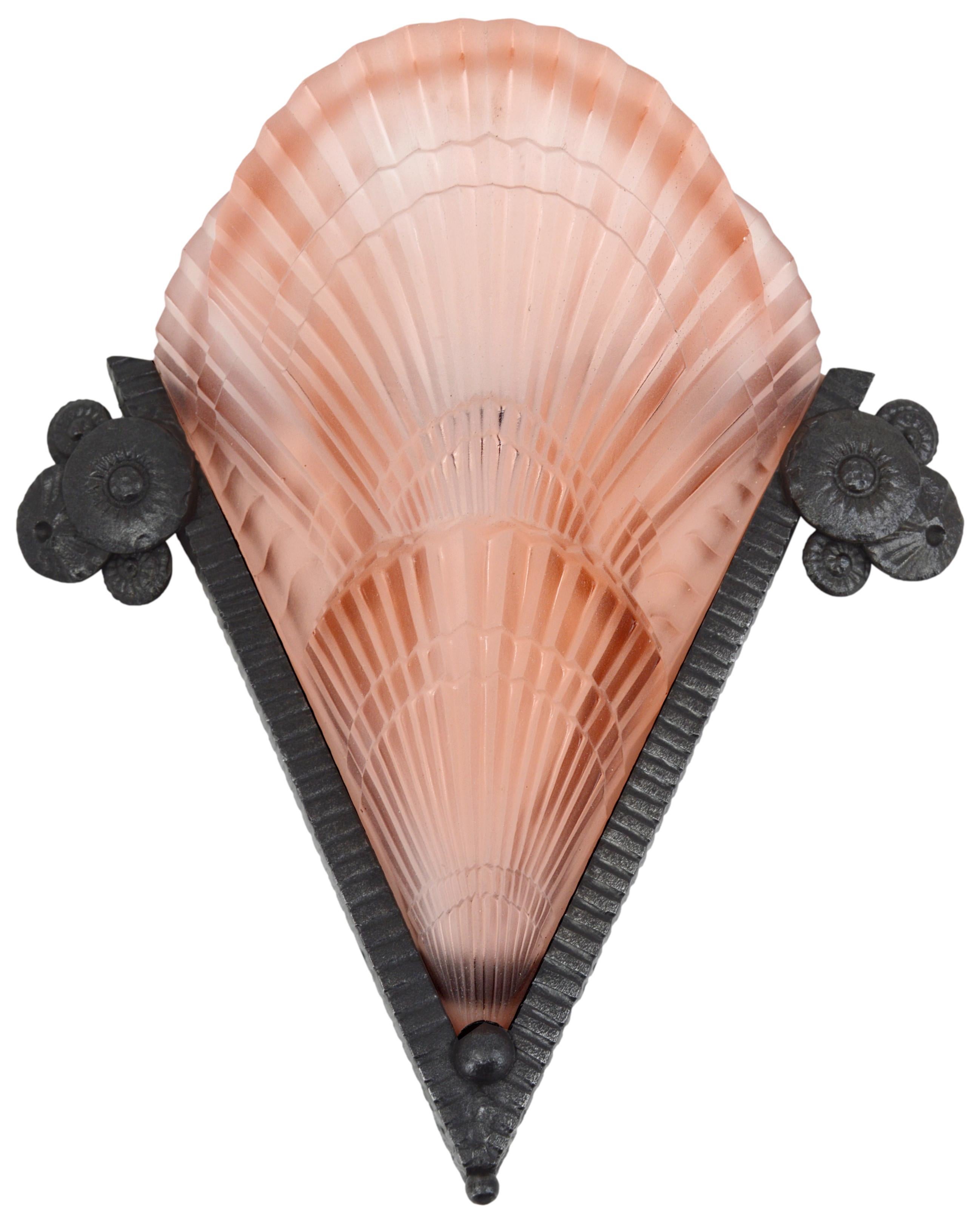 French Art Deco pair of wall sconces by Jean Noverdy (Dijon) and Marcel Vasseur (Paris). Thick pink molded glass shades by Noverdy. Wrought-iron backplates by Marcel Vasseur. Each - height : 12.2