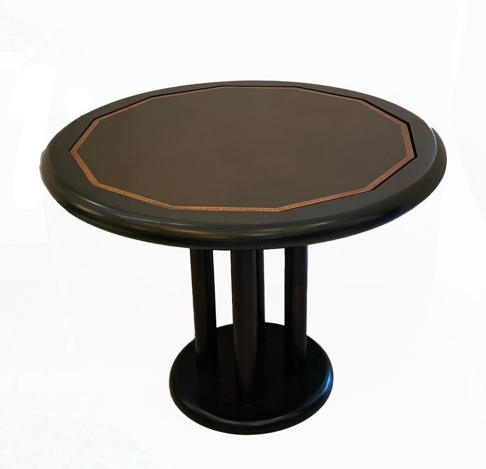 Brazilian hardwood card table. By Novo Rumo. The round circular top supported by four two inch columns on a round circular base. veneered Brazilian hardwood. covers the top. and base. The Top flips over to expose a green felt card playing surface.