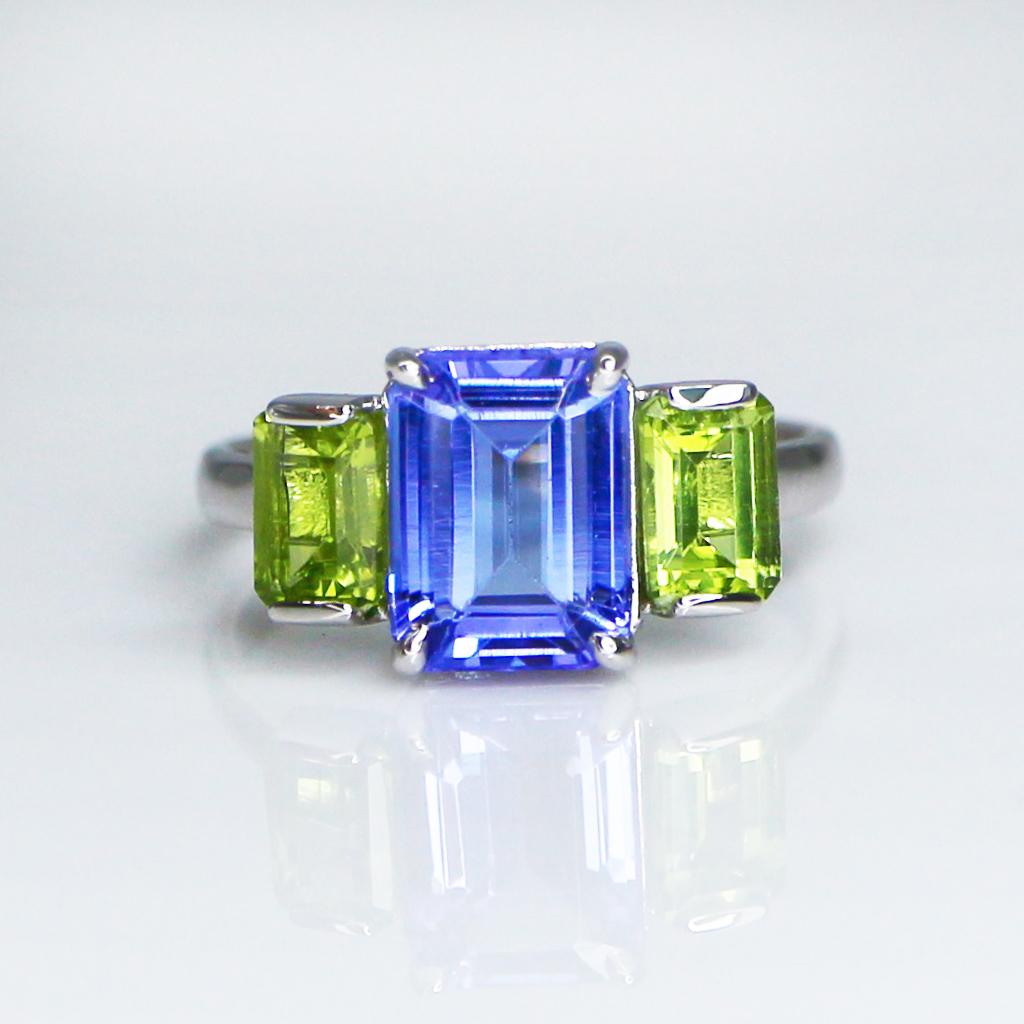 **One IGI 14K White Gold 2.00 Ct Tanzanite&Peridots Engagement Ring**

One IGI-Certified natural violetish Tanzanite as the center stone weighing 2.00 ct surrounded by the natural green Peridots weighing 1.12 ct on the 14K white gold 3 stone design