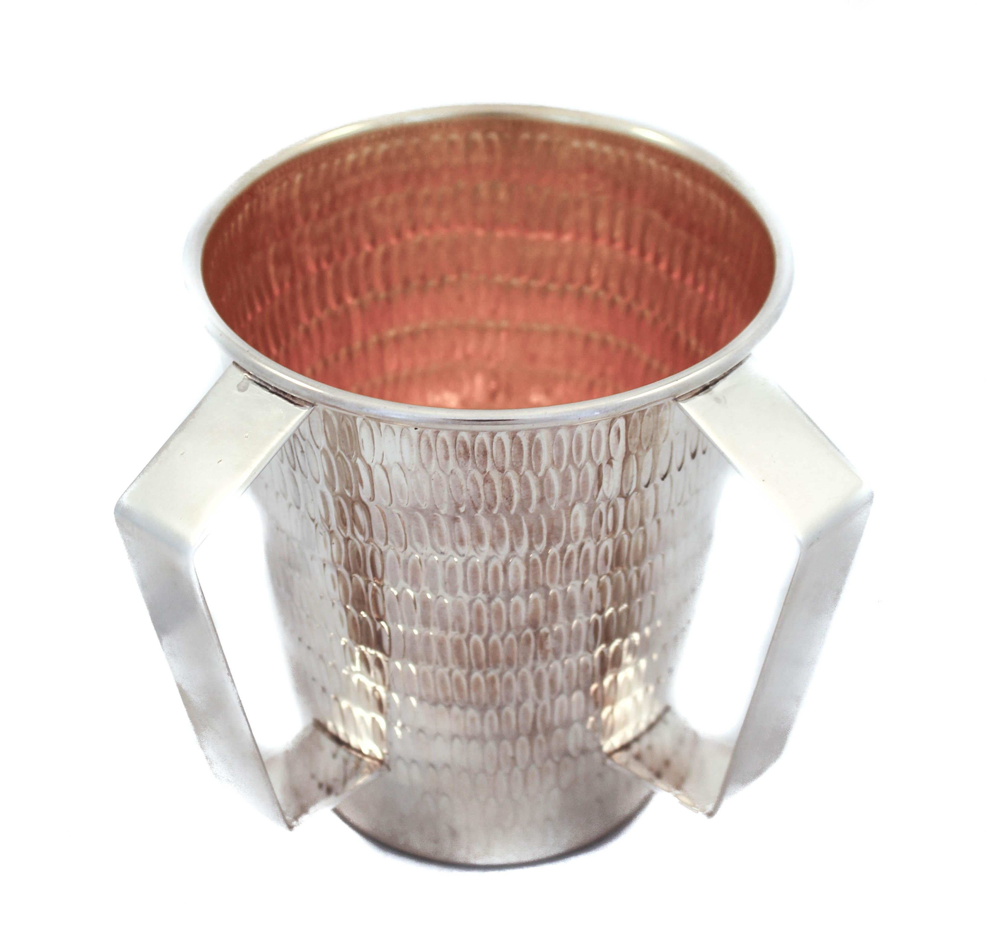 Being offered is a sterling silver washing cup (N’tillat Yadaiyim cup). This item is used to wash ones hands either before eating bread or performing religious requirements in the Jewish faith. 
It has a modern shape and design. Notice the straight