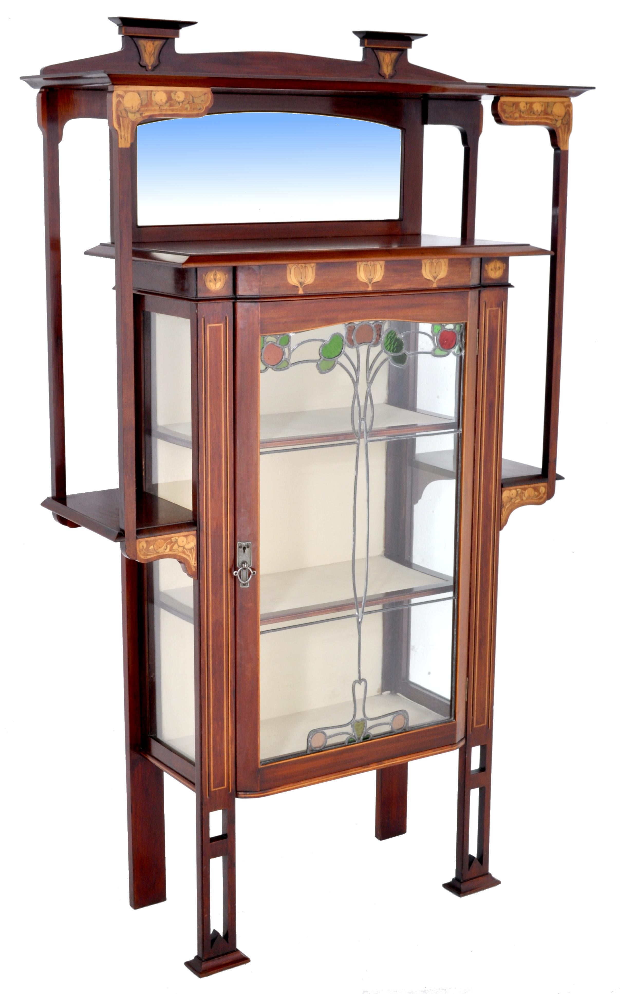 Antique Art Nouveau inlaid mahogany China cabinet by Shapland & Petter for Liberty of London, circa 1900. The cabinet finely inlaid with Art Nouveau style tulip designs and fruiting persimmons. The cabinet having an arched beveled mirror to the top,