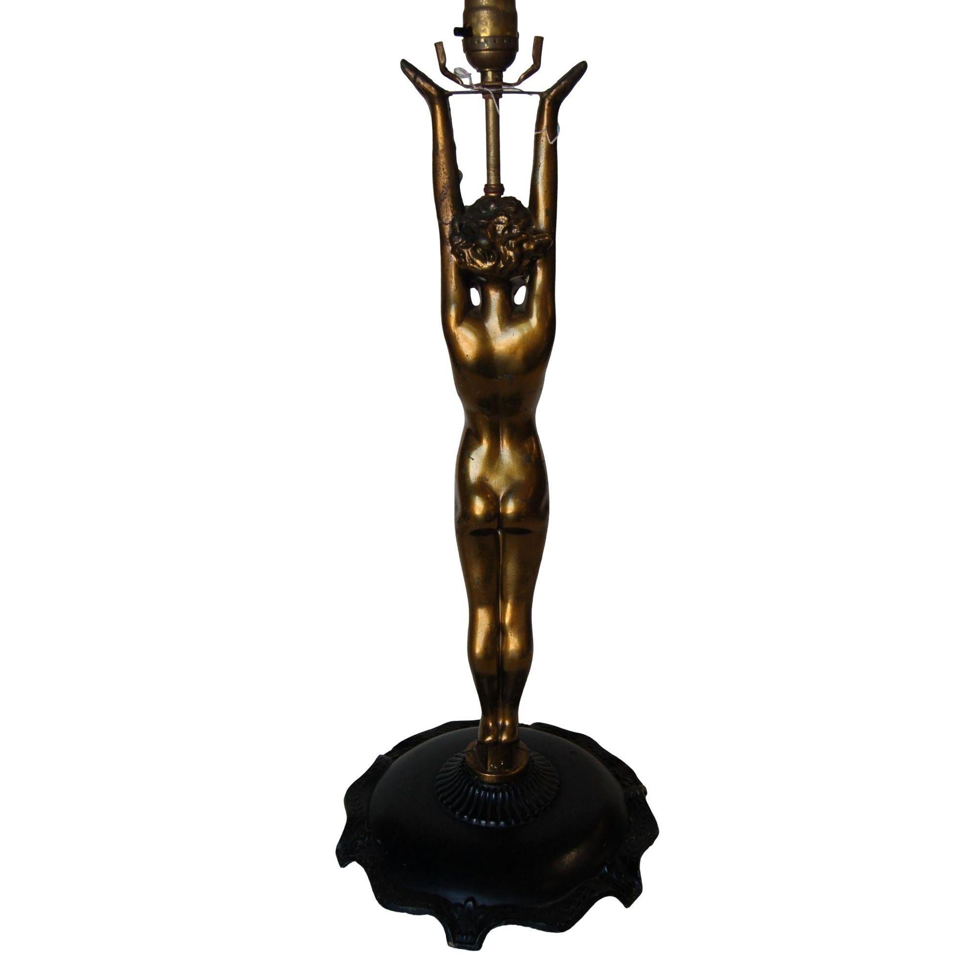 Magnifique lampe de table d'appoint Nuart en bronze avec une figure nue debout et des bras étendus sur une base en métal noir orné. 

Mesures : 11
