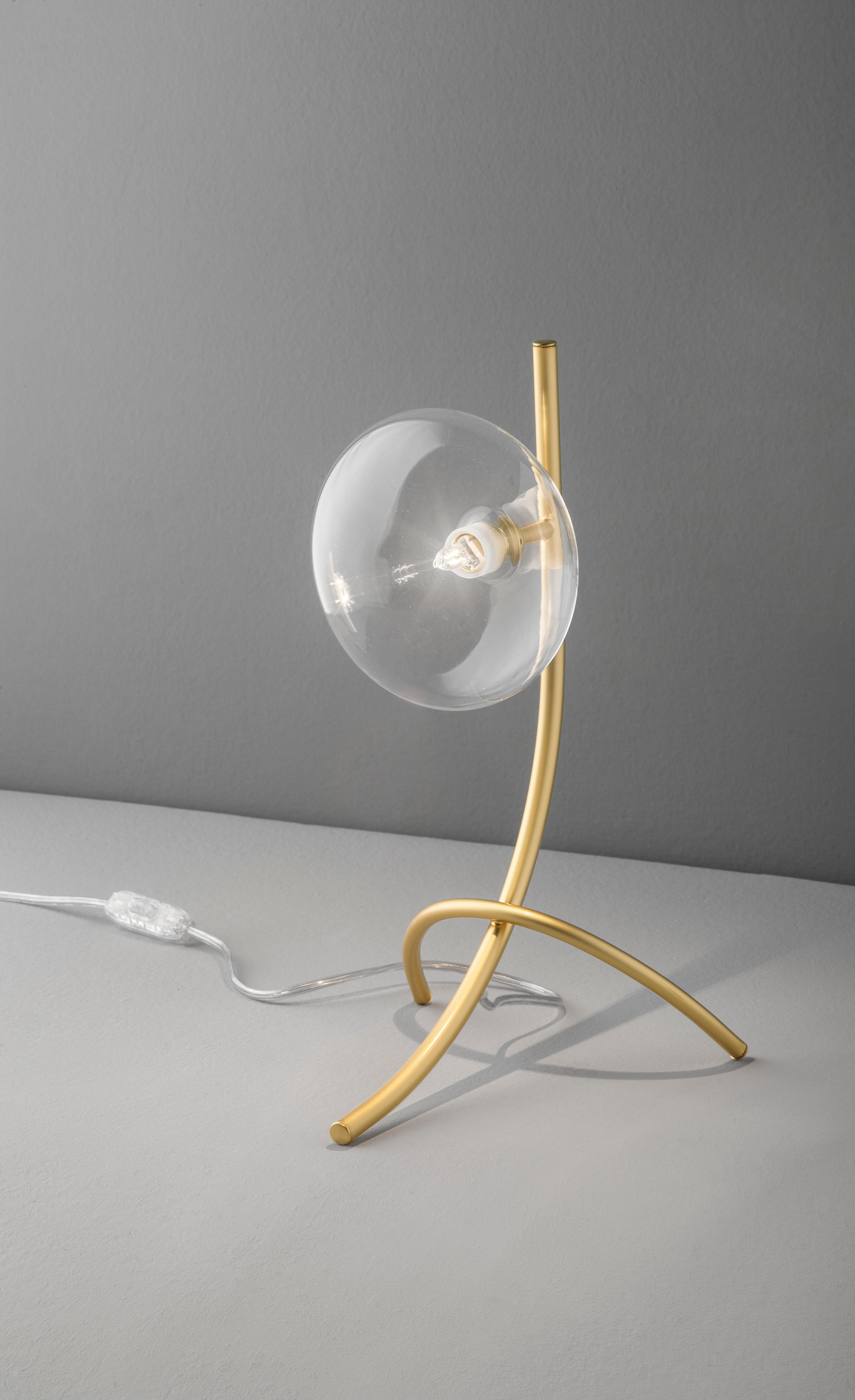 Modern Italian table lamp with a clear glass shade mounted on matt gold finish metal frame / Made in Italy by Fabio Ltd
Height: 12.5 inches / Width: 8 inches / Depth: 8 inches 
1 light / G9 type / max 25W
Order only / This item ships from