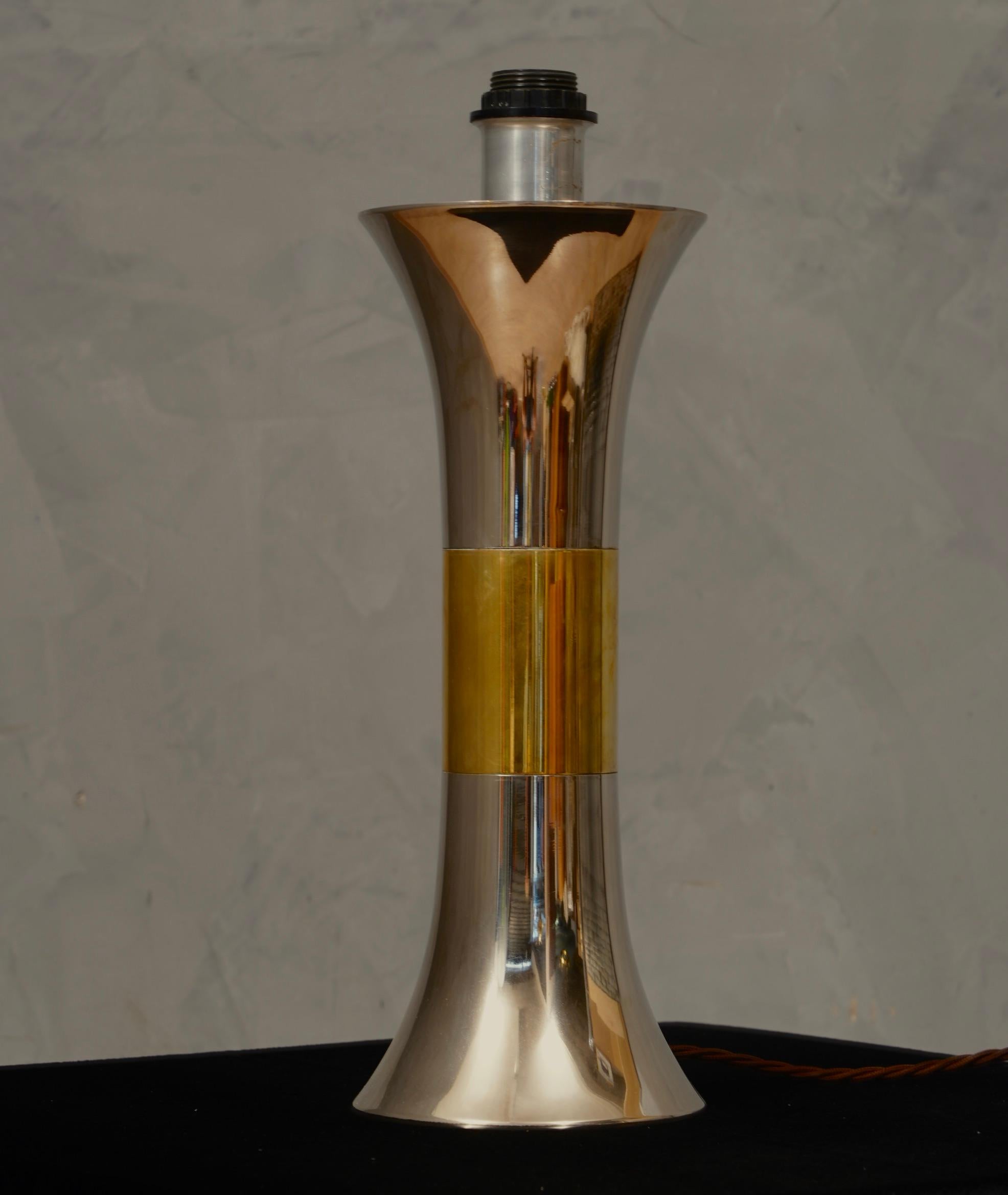 Refined and particular table lamp by Nucci Valsecchi, clean in its style, the table lamp is full of precious and distinctive materials.

The table lamp has a round shape and is made of steel and brass. Its style is very linear, in fact it starts