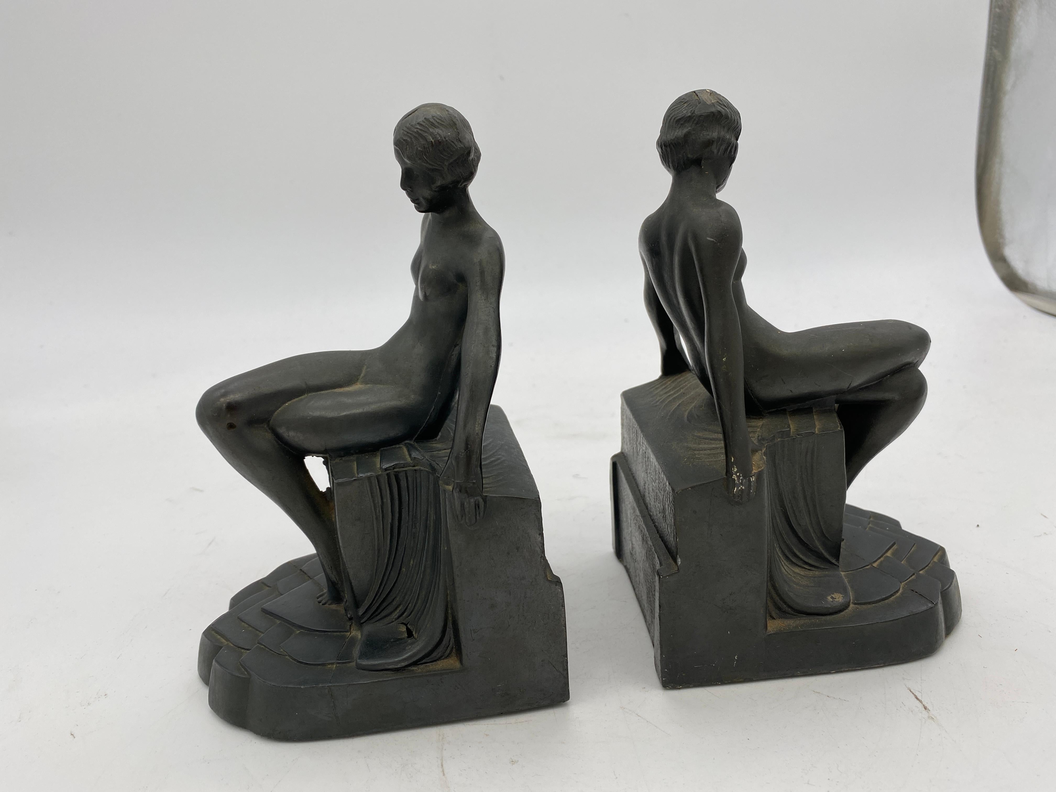 Original nude Art Deco flapper girl spelter metal bookends by Nuart featuring nude women sitting on a pedestal.