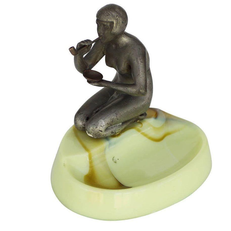 Made by Houzex, this brown and green slag ashtray features a spelter metal sculpture of a nude flapper girl smoking a long pipe. This is a great example of early Art Deco design and is reminiscent of the design and quality found in Frankart and