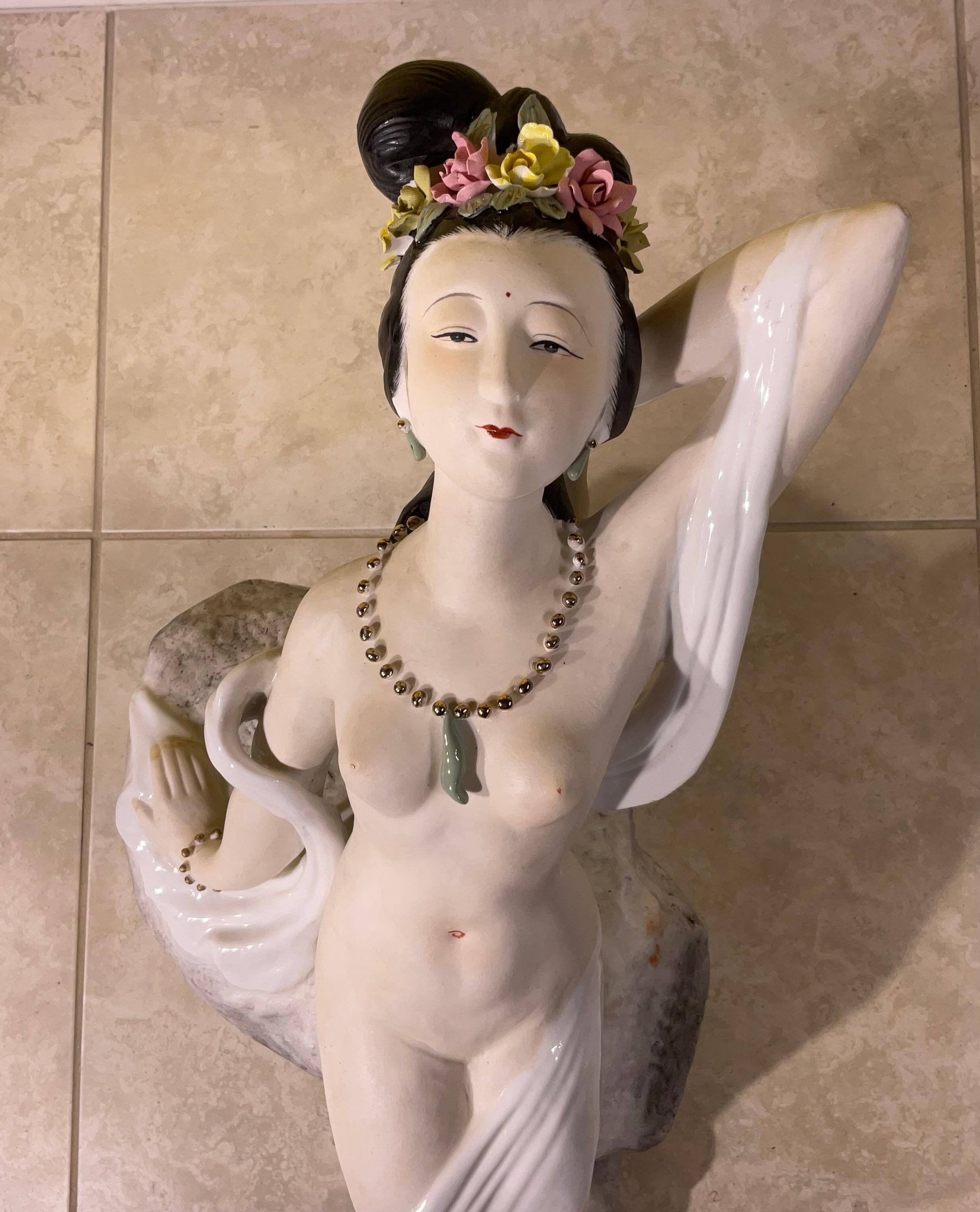 Beautiful oriental nude Porcelain woman figure, a decorative object of art made of porcelain , crafted with attention to detail, capturing the graceful curves and contours of the female form. The combination of porcelain and hand painted flowers