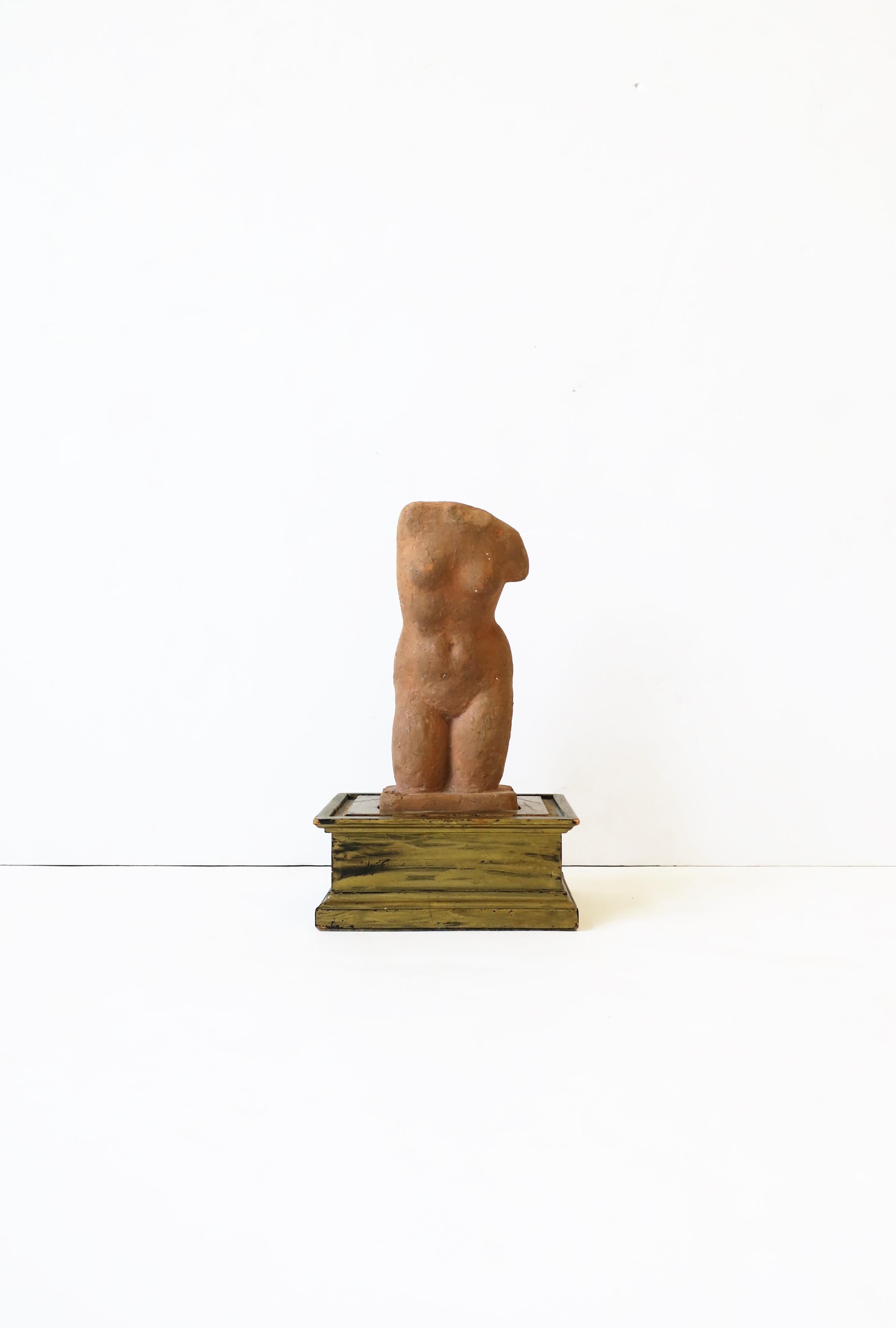 A vintage nude female torso sculpture of Aphrodite, a Greek Goddess, made of terracotta, on a rectangular wood base with a gold paint overlay, circa 20th century, from Paris, France. Sculpture is a reproduction based on Aphrodite from a French