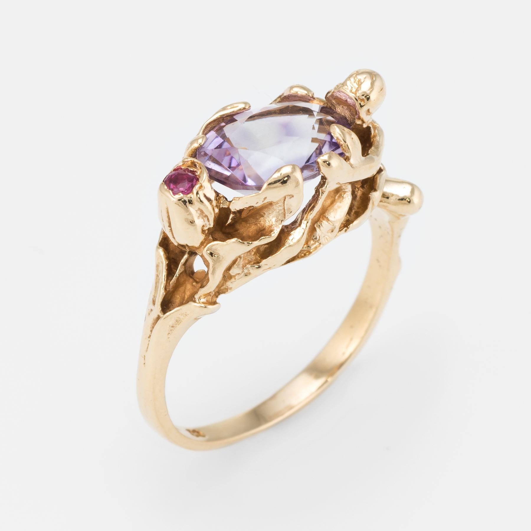 Finely detailed vintage ring, crafted in 14 karat yellow gold. 

Centrally mounted oval faceted amethyst measures 10mm x 8mm (estimated at 2.50 carats), accented with an estimated 0.02 carat ruby. The stones are in excellent condition and free of