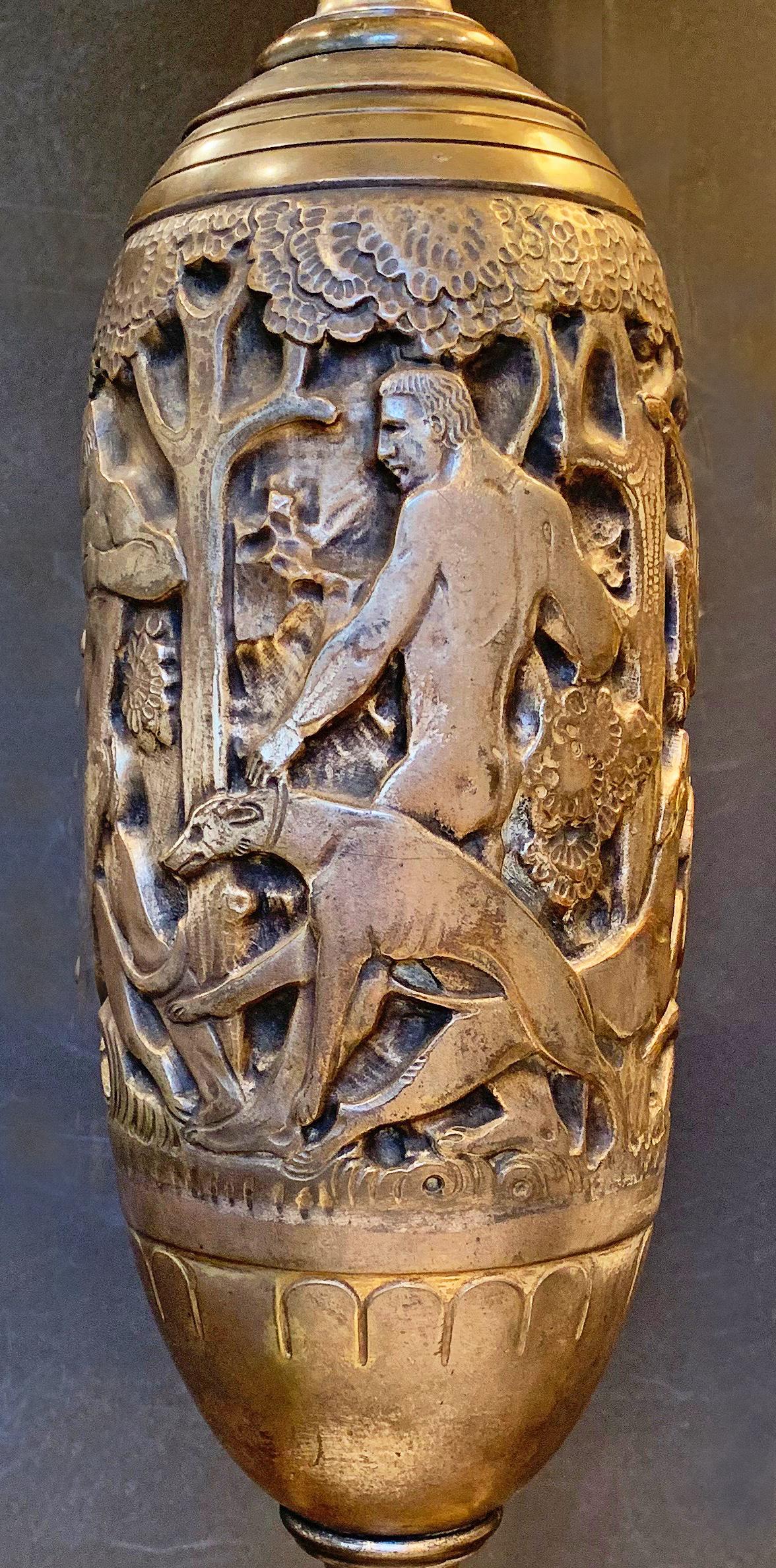 One of the great masterworks of American Art Deco, and probably unique in Oscar Bach's oeuvre, this large bronze and marble table lamp depicts two nude male figures, accompanied by several hounds, on the hunt for a stag in the forest. The