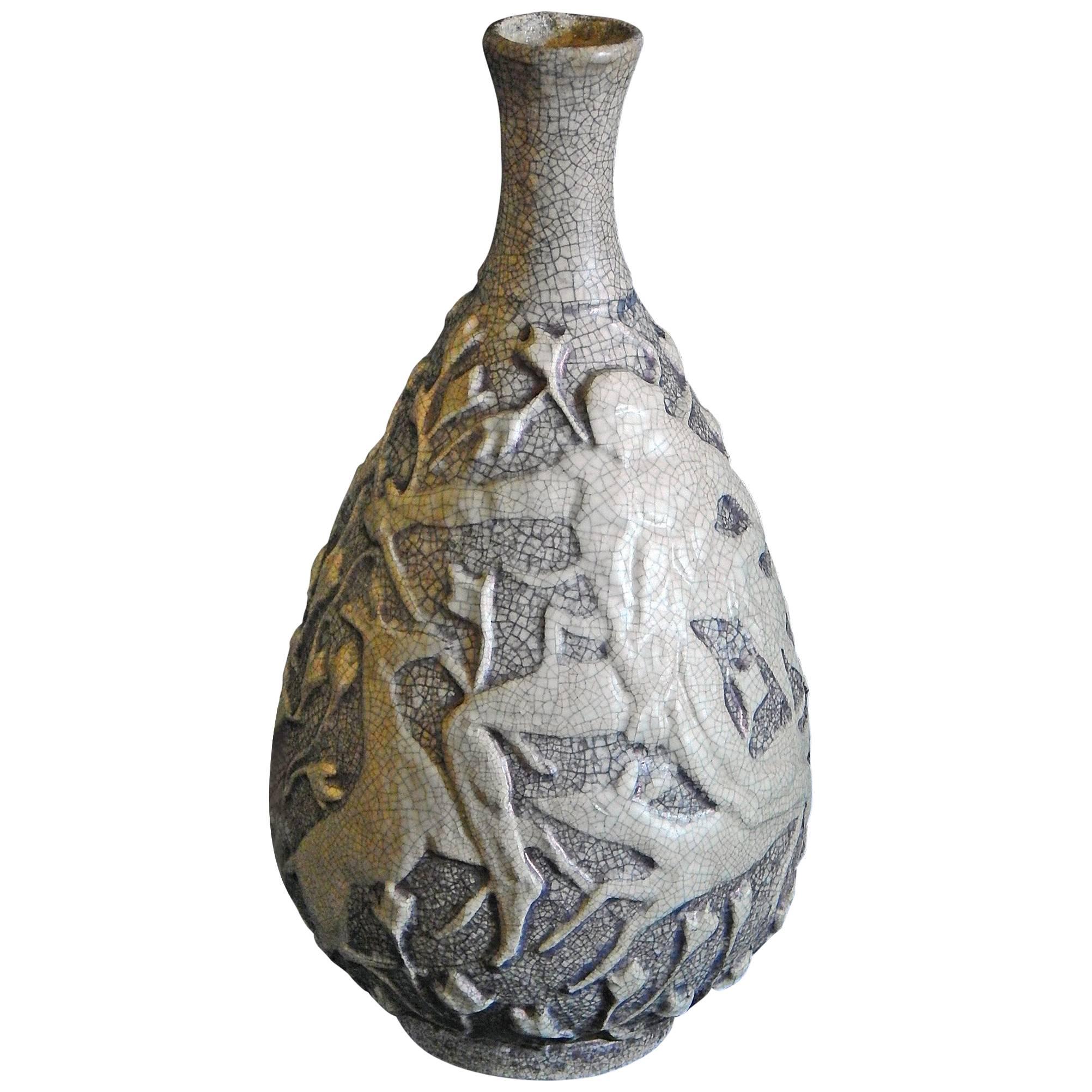Ce vase très inhabituel de Jean Mayodon, l'un des principaux artistes français de l'époque Art déco, représente deux scènes de chasseurs masculins nus avec plusieurs cerfs. L'un des chasseurs est représenté avec un grand arc arqué - un thème