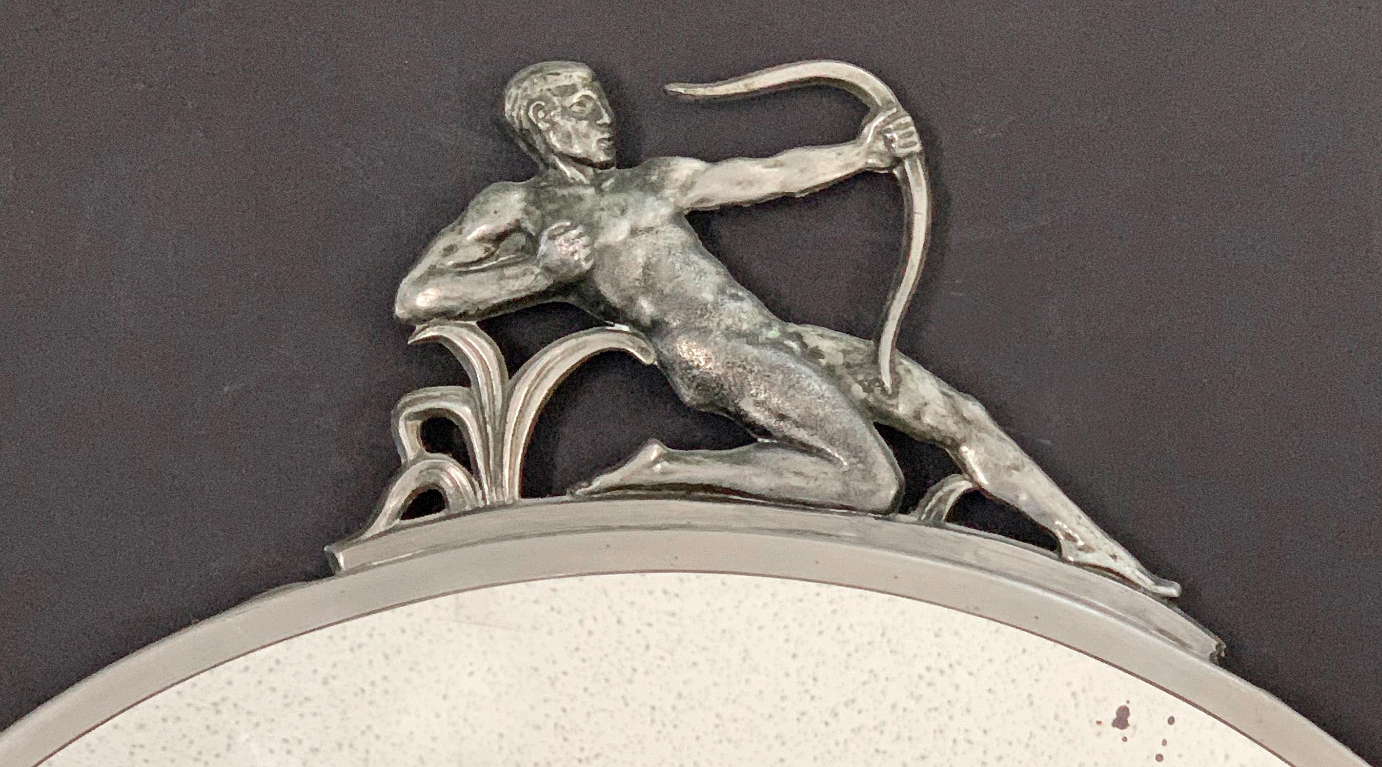 This gorgeous circular mirror surmounted by a nude male Archer figure in bas relief pewter was made in 1930s Sweden, strongly influenced by the Swedish Grace movement and the Svenskt Tenn company in particular, which commissioned Swedish artists to