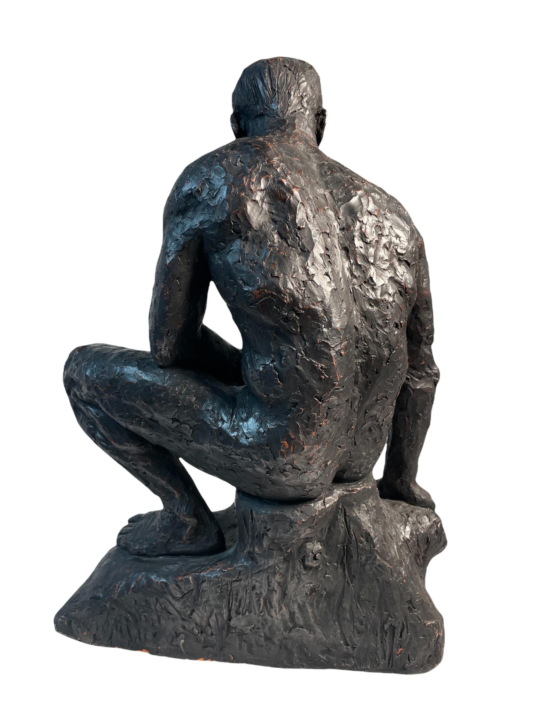 Large clay sculpture of the seated male form by contemporary British artist David T Waller. The clay is roughly shaped by hand giving it a textured appearance and is then painted black to heighten the modelled form and simulate the appearance of
