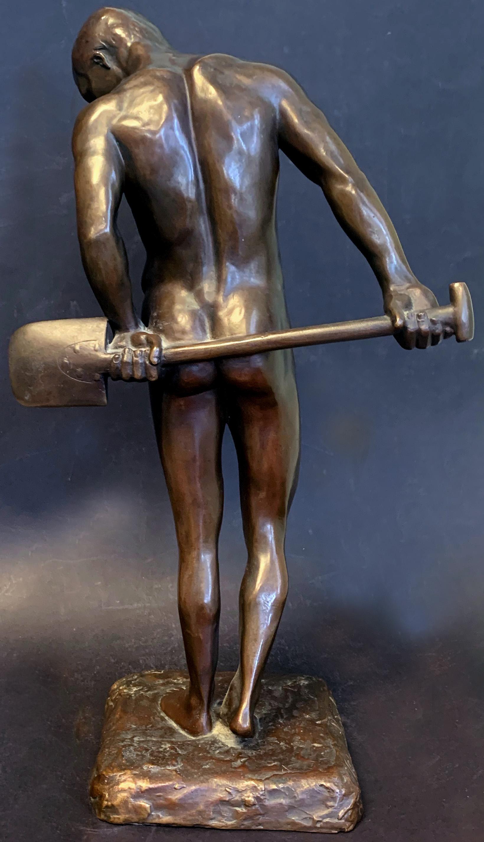 Œuvre rare d'Oskar Lindenberg, un sculpteur allemand qui a produit peu de pièces durant ses années productives, ce beau bronze d'homme nu capture son sujet avec la tête tournée vers le bas et la gauche, les mains derrière lui, tenant une pelle en