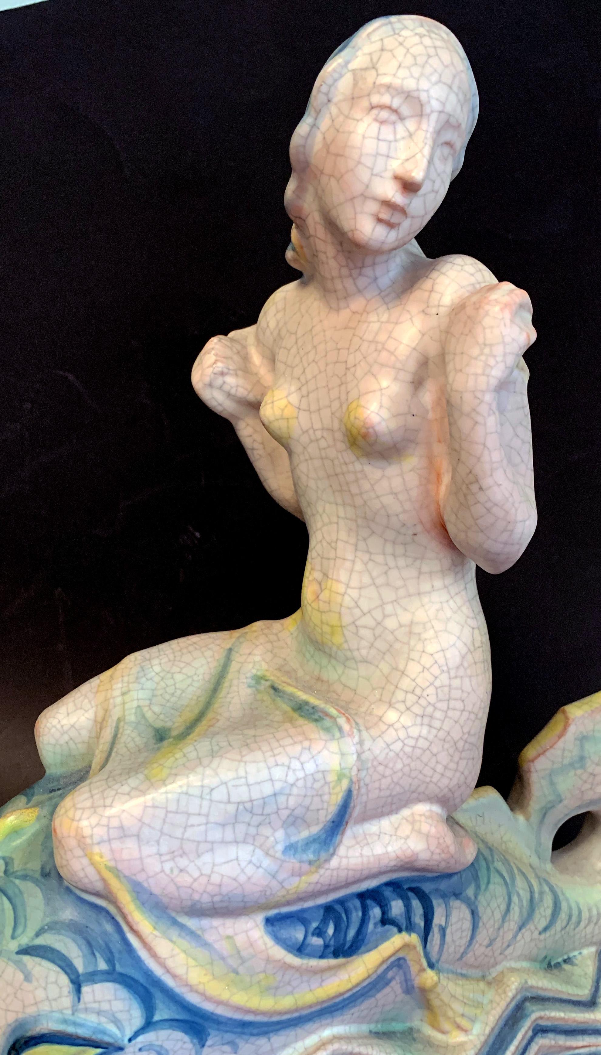 Stunning in its size, composition and rich glazes, this rare sculpture of a mermaid riding on a dolphin in an Art Deco, zigzag sea was crafted by Kieler Kunst-Keramic in Kiel, Germany in the mid-1920s. Known by Art Deco collectors for its exquisite