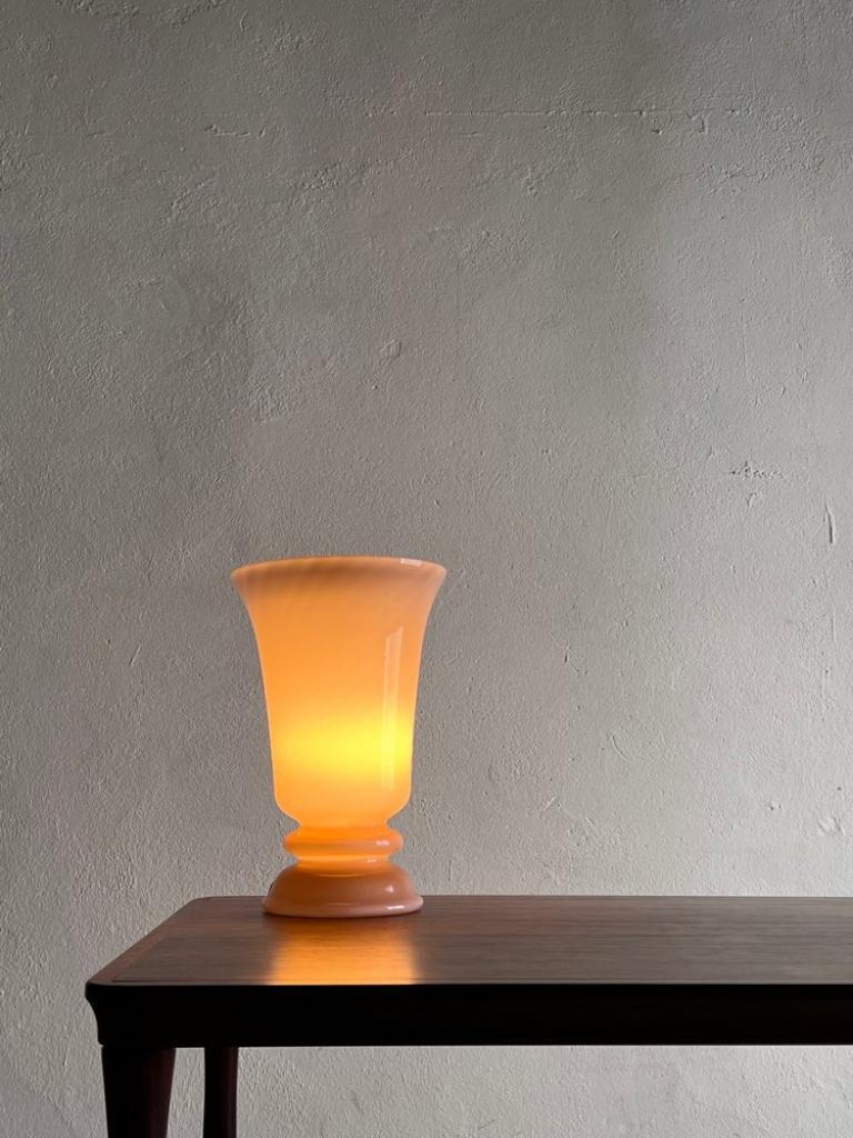 Mid-century nude hue glass table lamp.

Additional information:
Country of manufacture: Sweden
Design period: 1960s
Dimensions: 18.5 cm D (upper) x 28 H cm
Condition: Good vintage condition - some insignificant chips on the edges