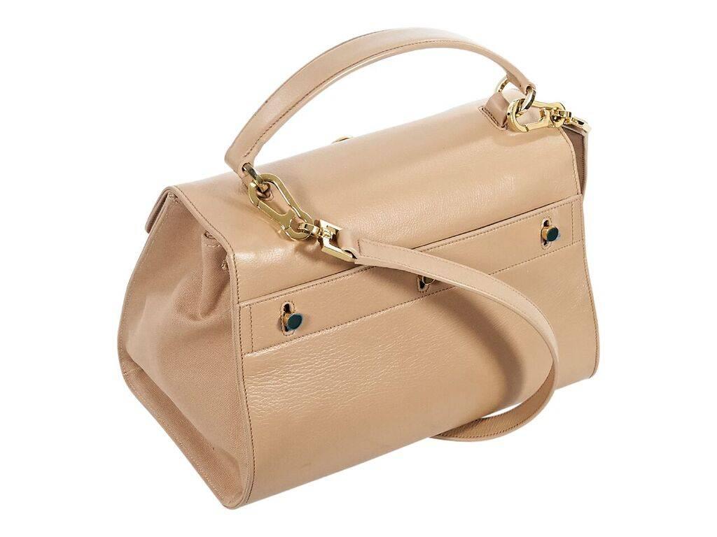 Product details:  Nude leather and canvas Moujik top handle bag by Saint Laurent.  Top carry handle.  Detachable shoulder strap.  Front flap with push-lock closure.  Lined interior with inner center zip compartment.  Protective metal feet.  Goldtone