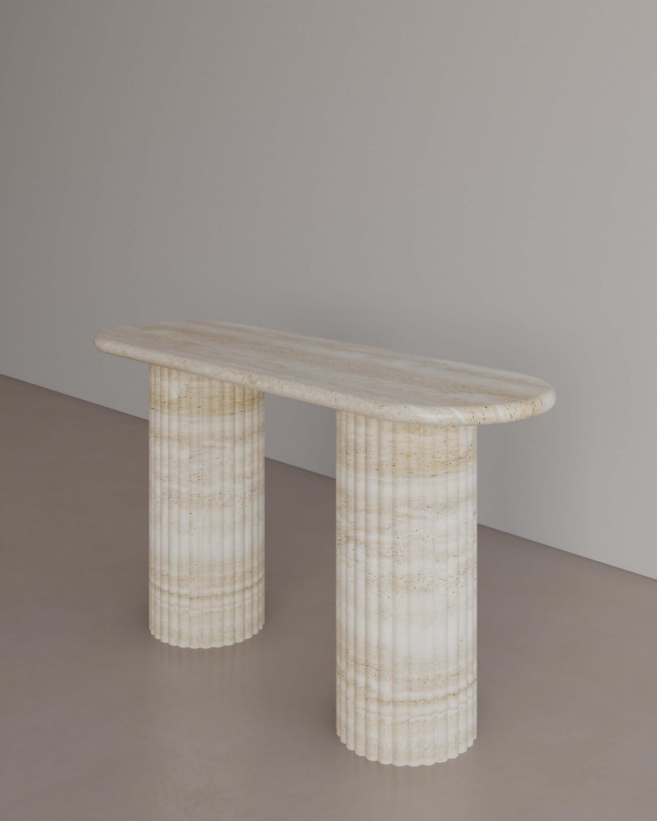 The Essentialist presents The Antica Console table in Nude Travertine. Featuring two Roman-style pillars, used throughout the Empire’s history to celebrate conquest and victory. Featuring a sensuous, elongated oval top with bullnose edges resting on