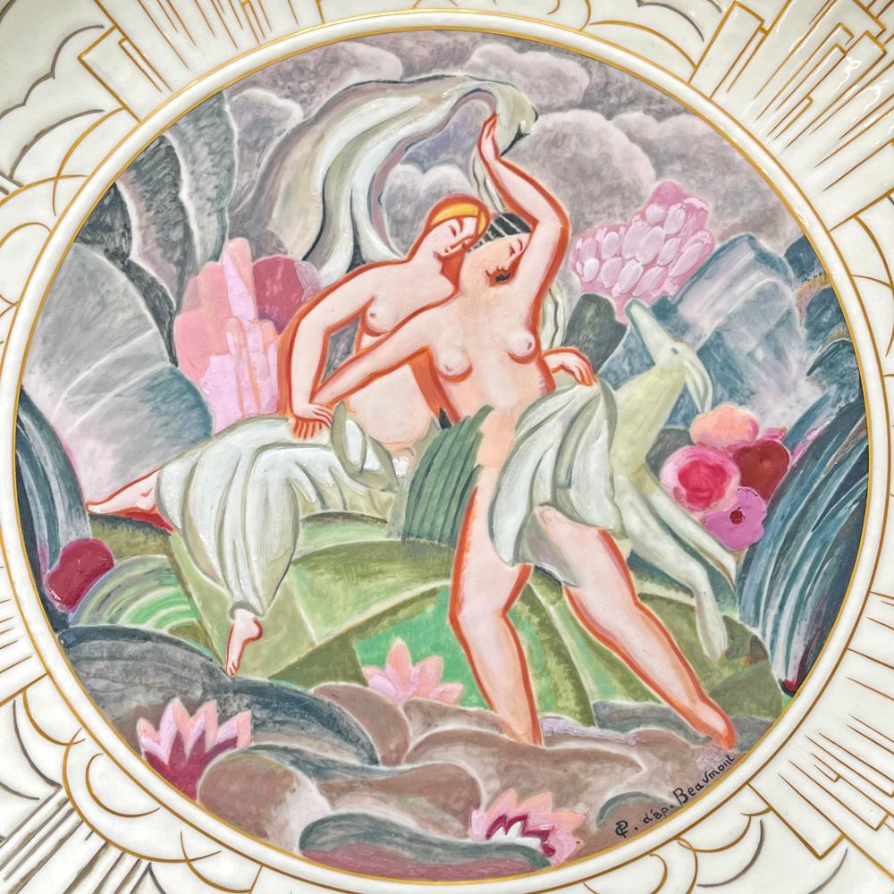 Una de las piezas Art Déco de alto estilo más espectaculares que hemos ofrecido nunca, este gran cargador de pared que representa dos desnudos femeninos y un ciervo en un idílico jardín empapado de color fue fabricado en 1927 por la afamada