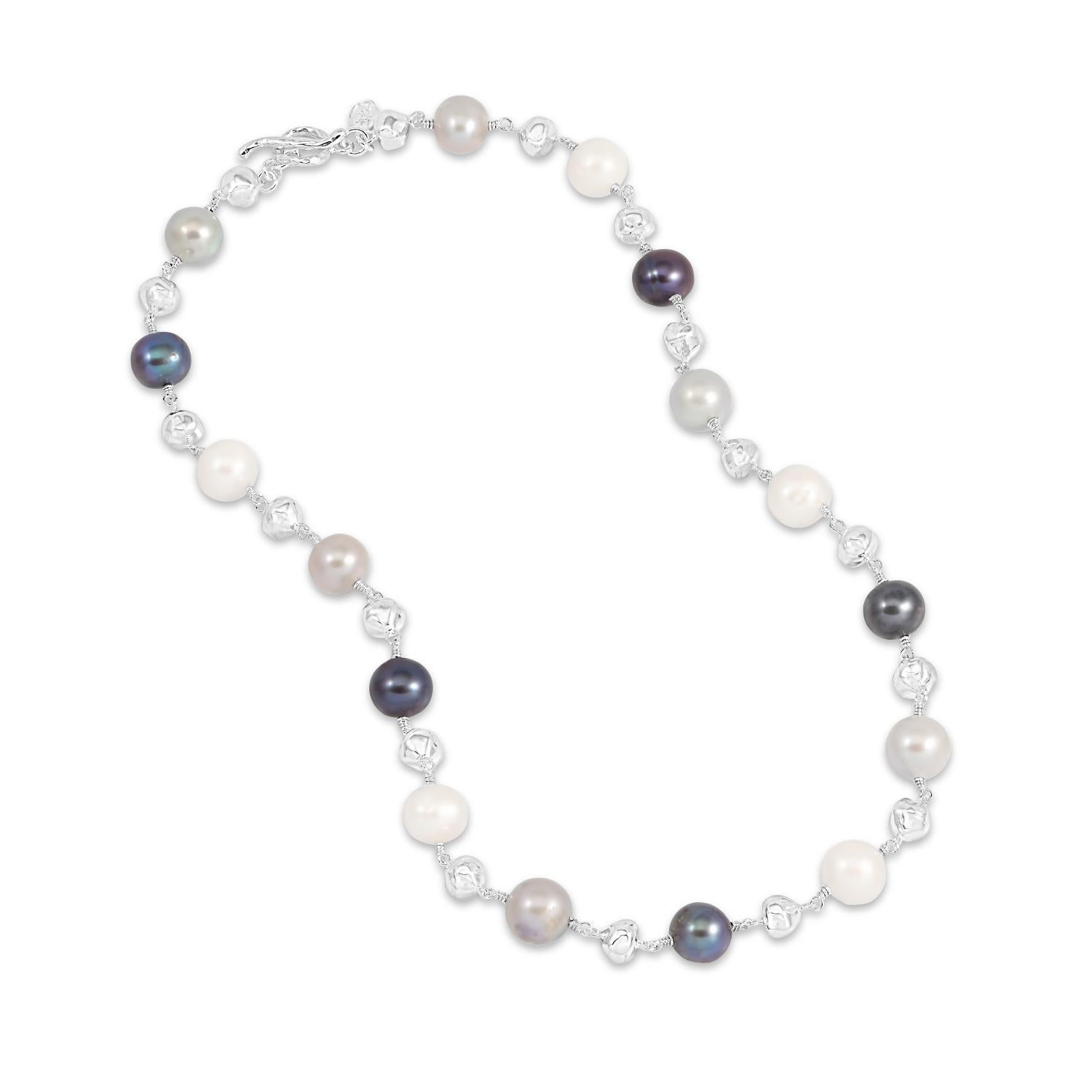 Diese Halskette aus unserer Luna Pearls-Reihe besteht aus gemischten Süßwasser-Zuchtperlen in Weiß, Taubengrau und Pfauentönen, die mit 7 Sterlingsilber-Nuggets durchsetzt sind. Die 5 mm großen Nuggets haben ein weiches, geschlagenes Finish, das der