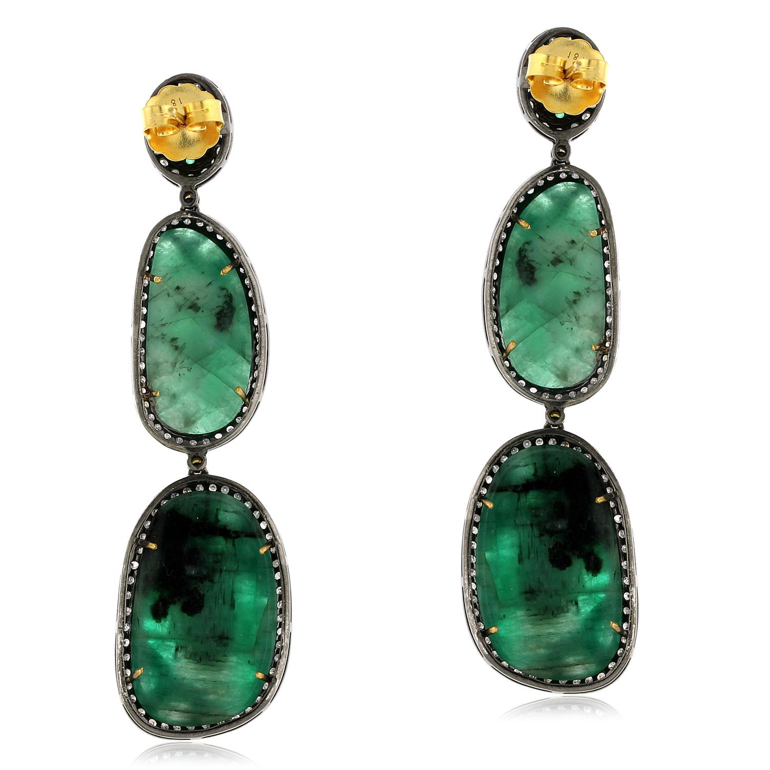 These earrings feature vibrant emeralds set in a unique nugget and opal shape, surrounded by sparkling pave diamonds. Crafted with 18k gold and silver, these earrings are both luxurious and