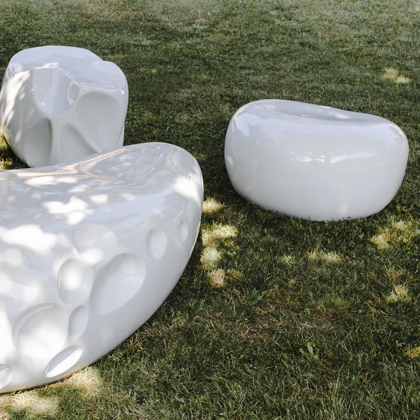 Crafted in reinforced resin to resemble an organic stone, the sculpture is suitable for both indoor and outdoor use. Shown here in white with a glossy finish, the piece can be personalized with any RAL color.
  