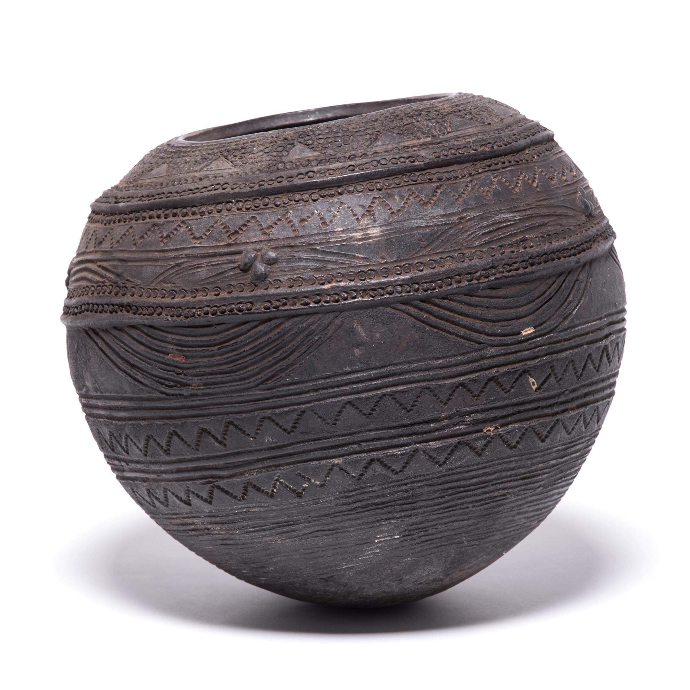 The Nupe people of Nigeria were touted as some of the finest ceramicists in Africa. This water vessel is a particularly fine example of their mastery. While most such items feature a small number of designs, the intricately interwoven bands, ridges,
