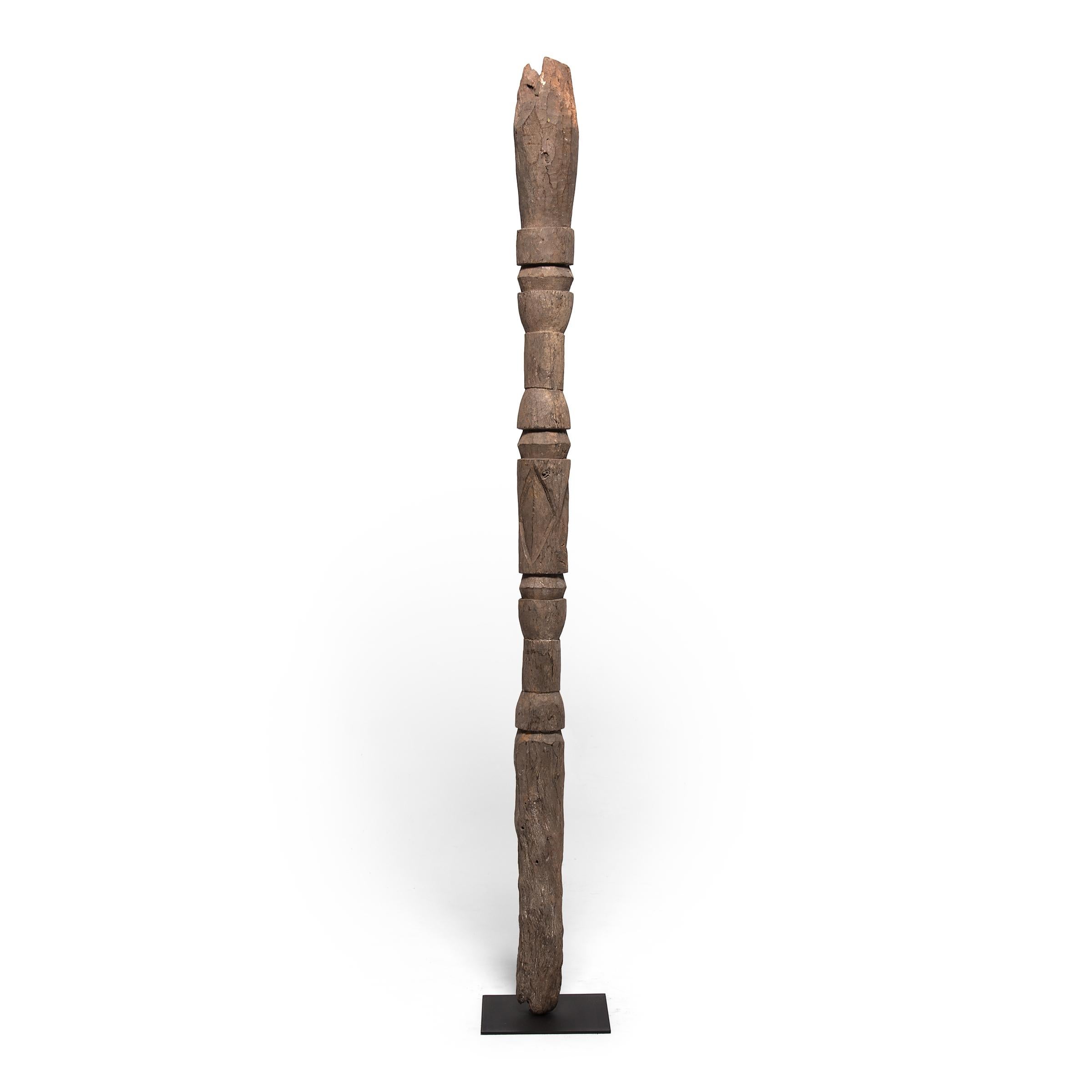 Hand carved with an abstract design, this tall wooden post was crafted by an artisan of the Nupe peoples of Nigeria and once stood as a central support beam for a family home. Nupe posts are typically carved with simple geometric forms, rather than