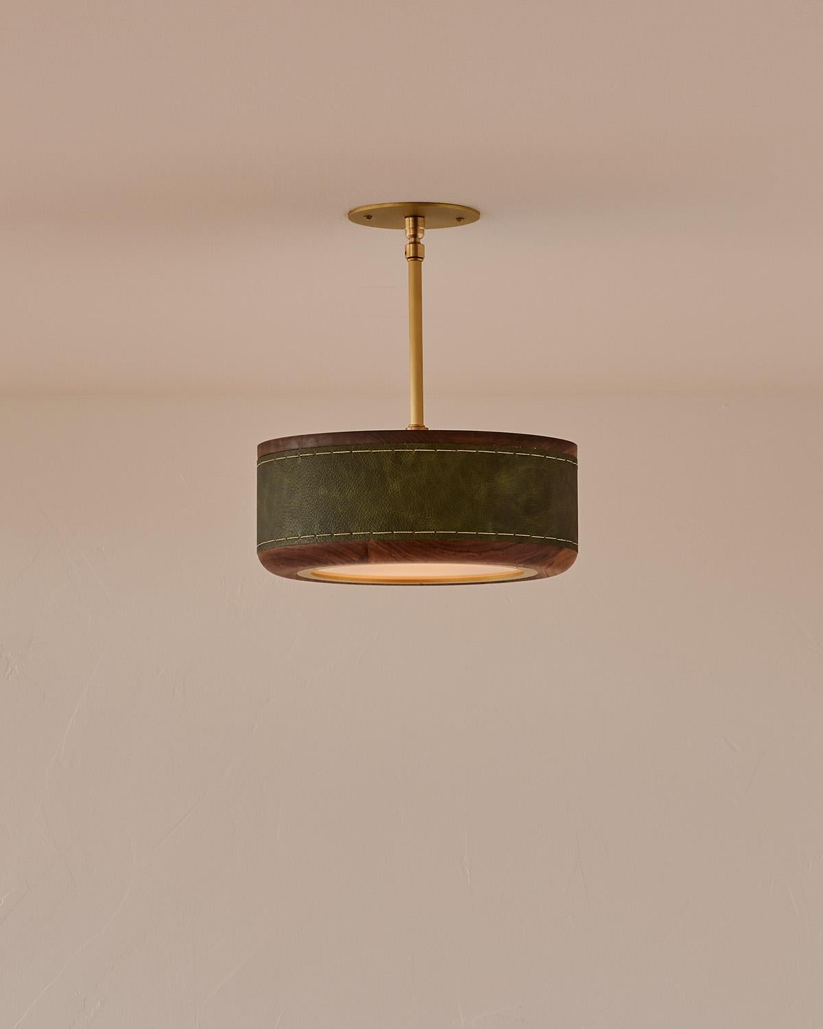 The Nura Ceiling Fixture combines hand-stitched leather over walnut accented by a brass pole and canopy. This fixture can either be hung as a ceiling surface mount or a pendant supported by a brass pole.

OVERALL DIMENSIONS
Shade: 12